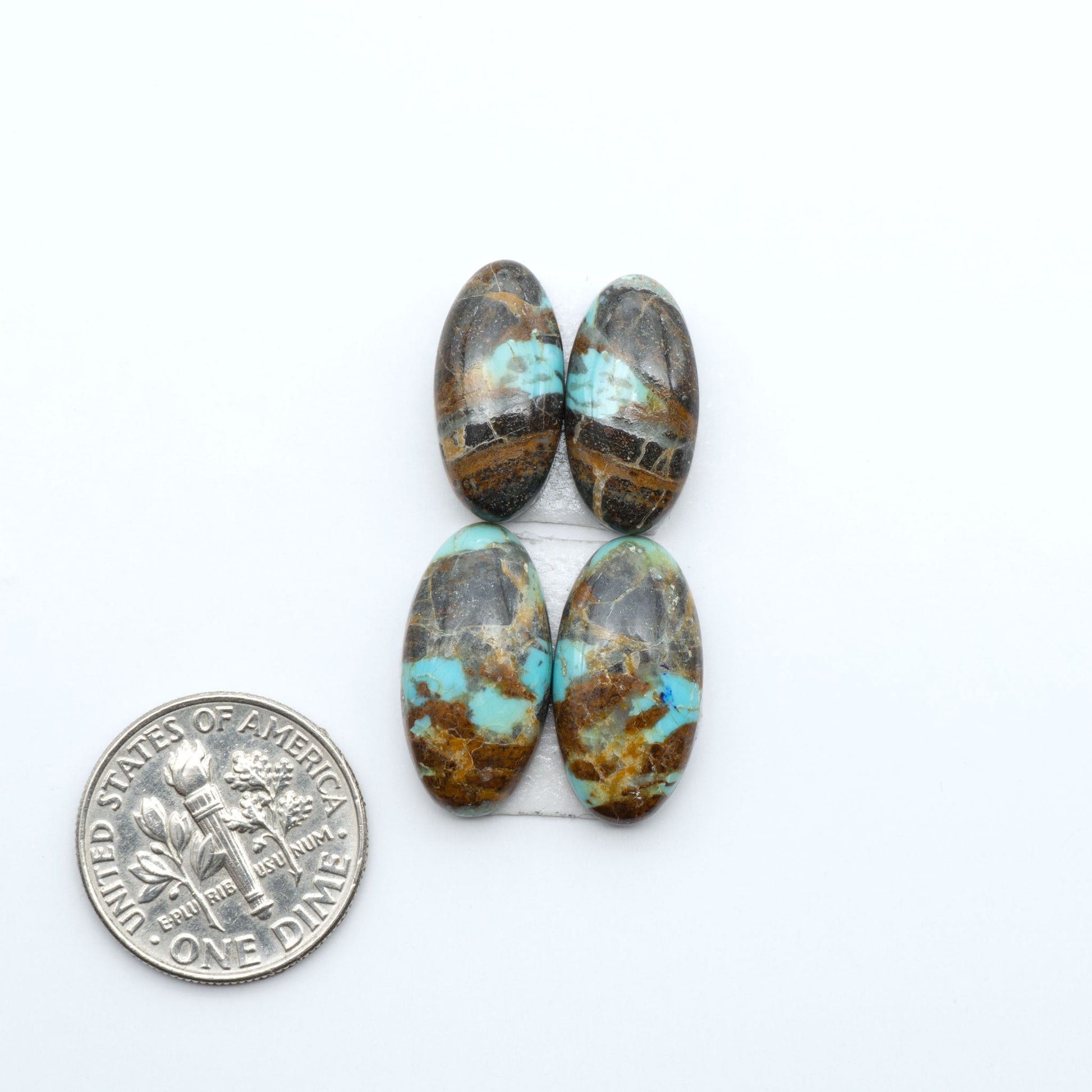 Number 8 Turquoise cabochons, blue and green color with brown matrix, polished stones on a white background, with a US dime for scale