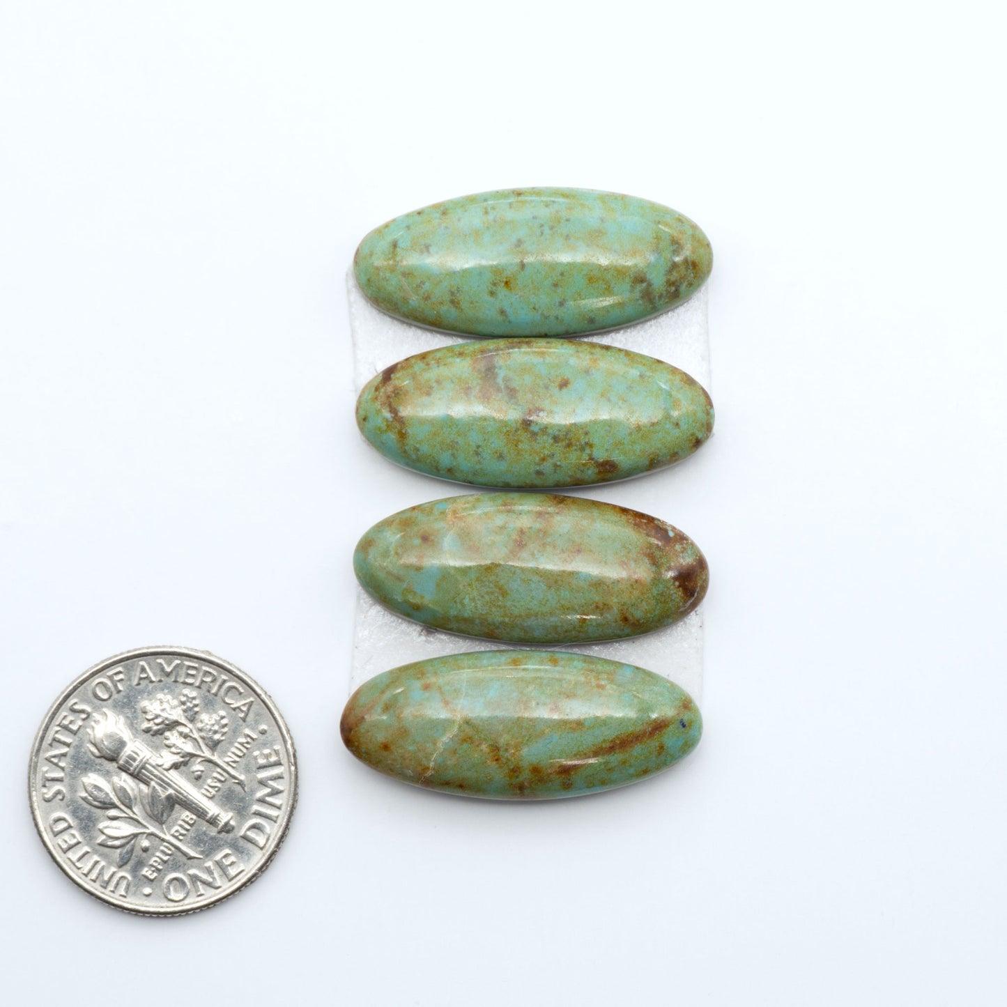 Number 8 Turquoise cabochons, blue and green color with brown matrix, polished stones on a white background, with a US dime for scale