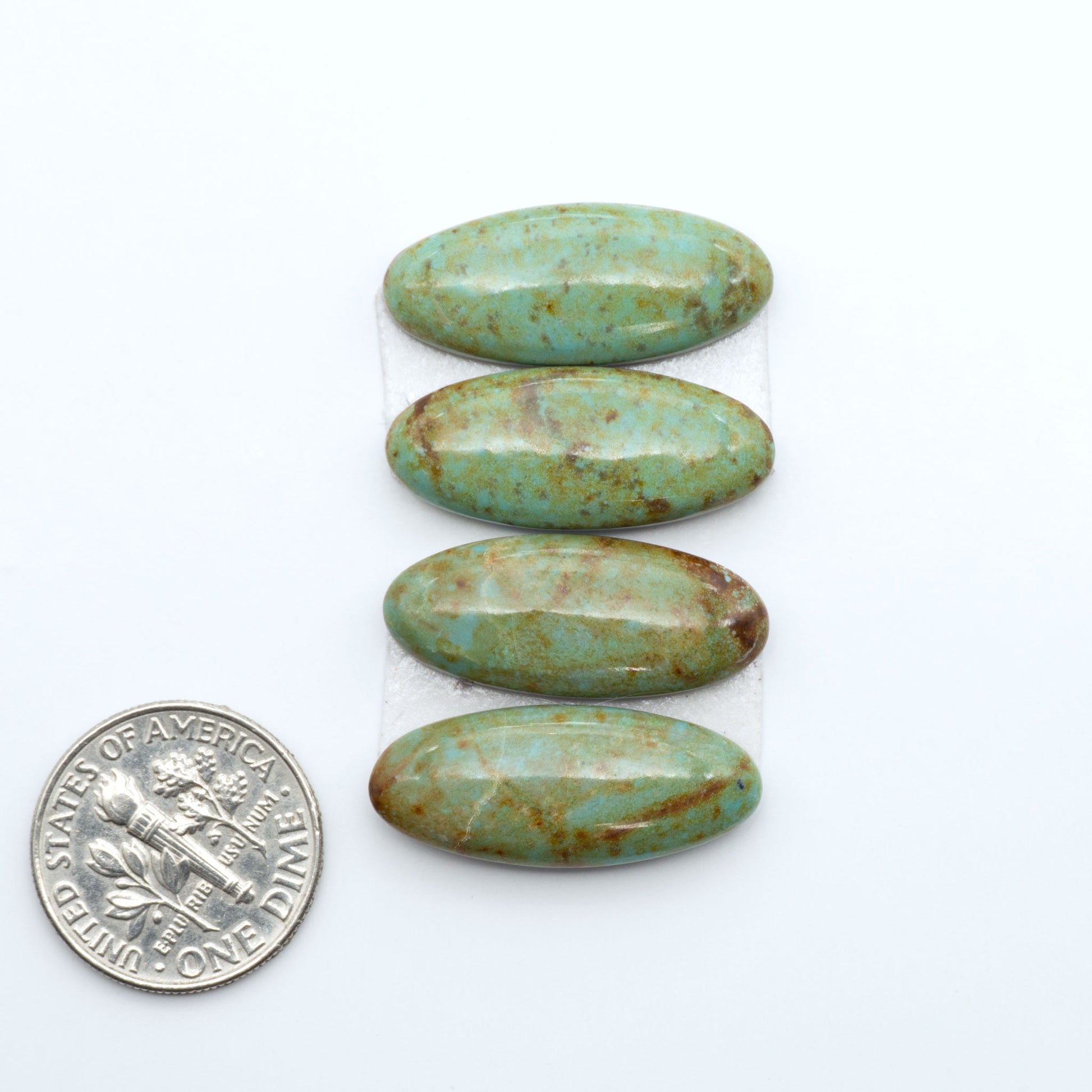 Number 8 Turquoise cabochons, blue and green color with brown matrix, polished stones on a white background, with a US dime for scale