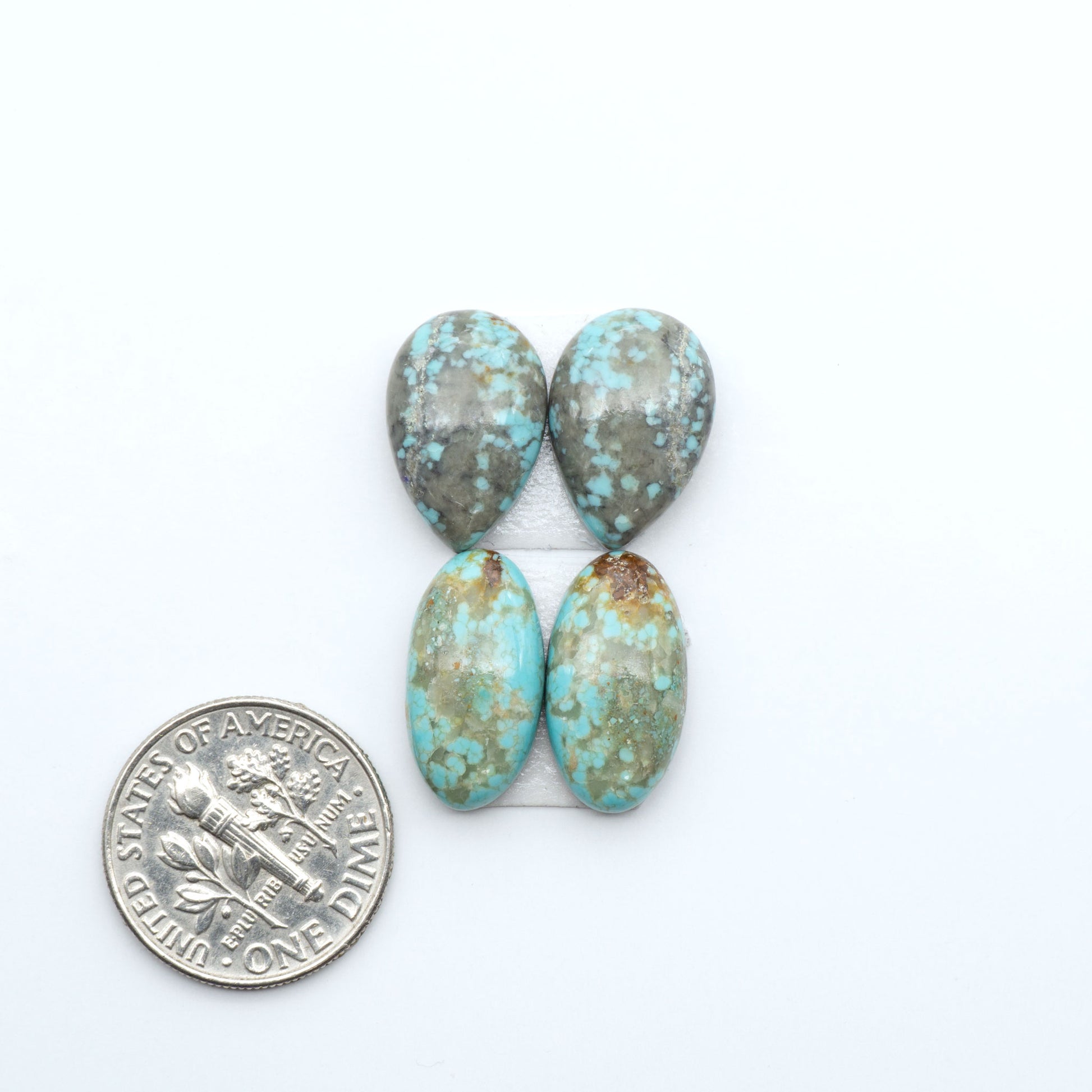Number 8 Turquoise cabochons, blue and green color with brown matrix, polished stones on a white background, with a US dime for scale