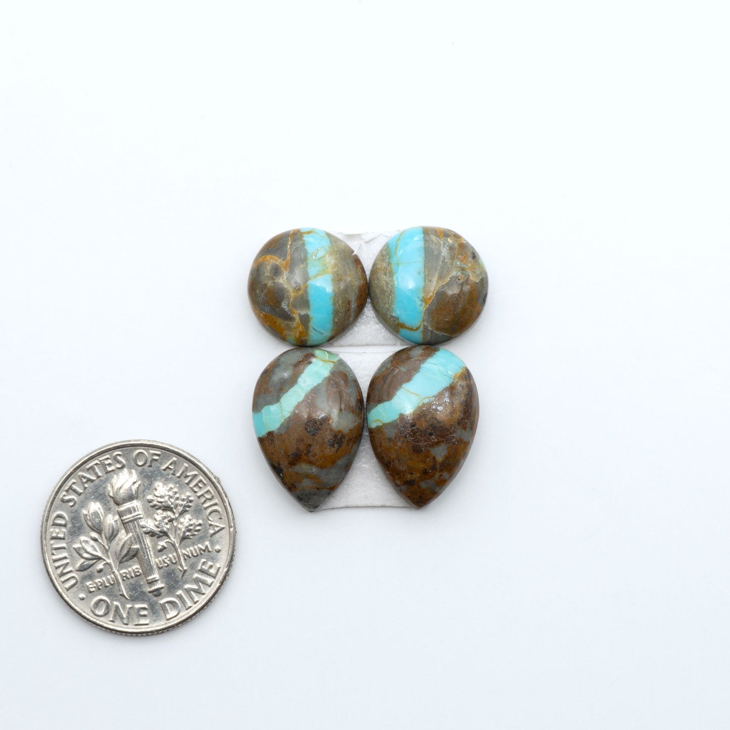 Number 8 Turquoise cabochons, blue and green color with brown matrix, polished stones on a white background, with a US dime for scale