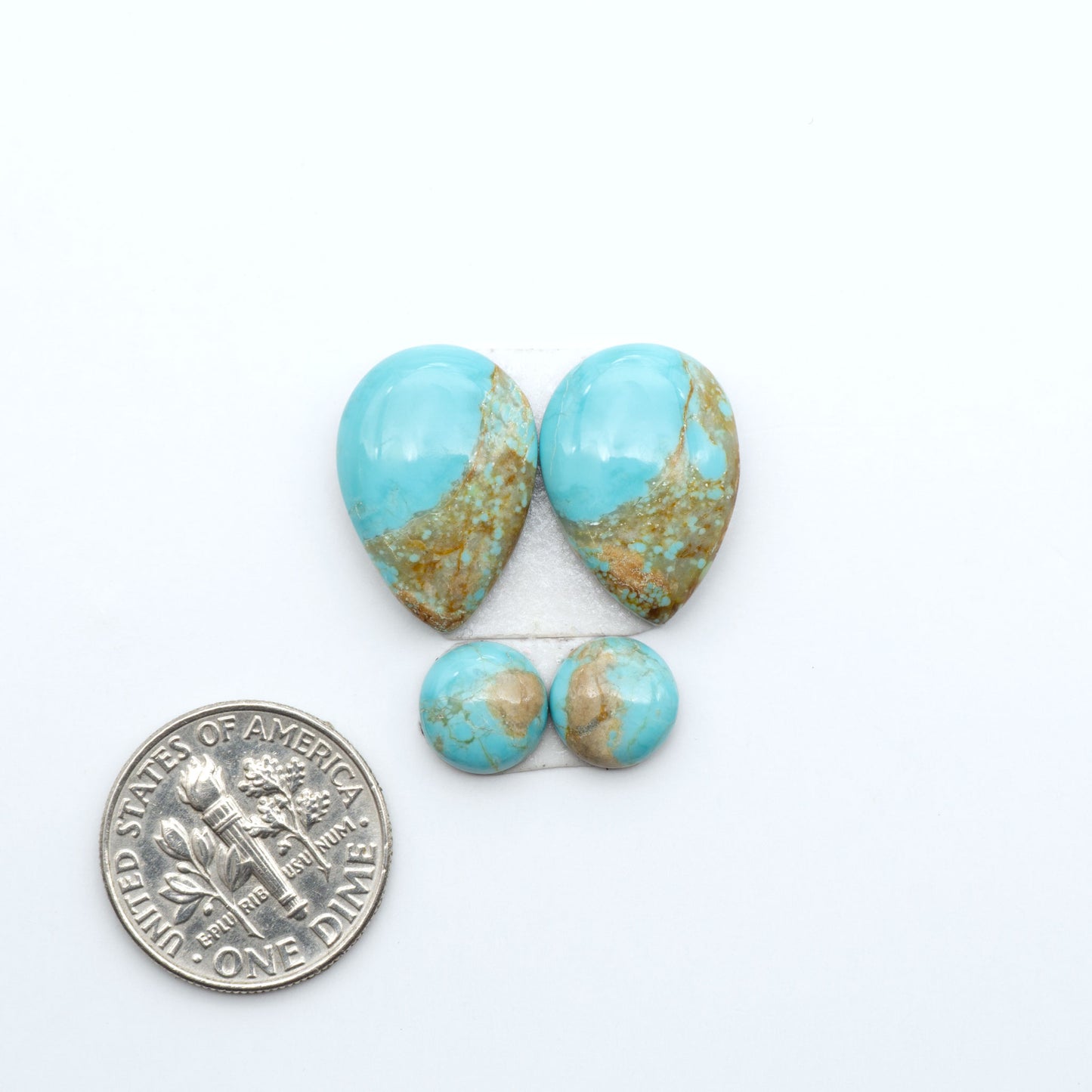 Number 8 Turquoise cabochons, blue and green color with brown matrix, polished stones on a white background, with a US dime for scale