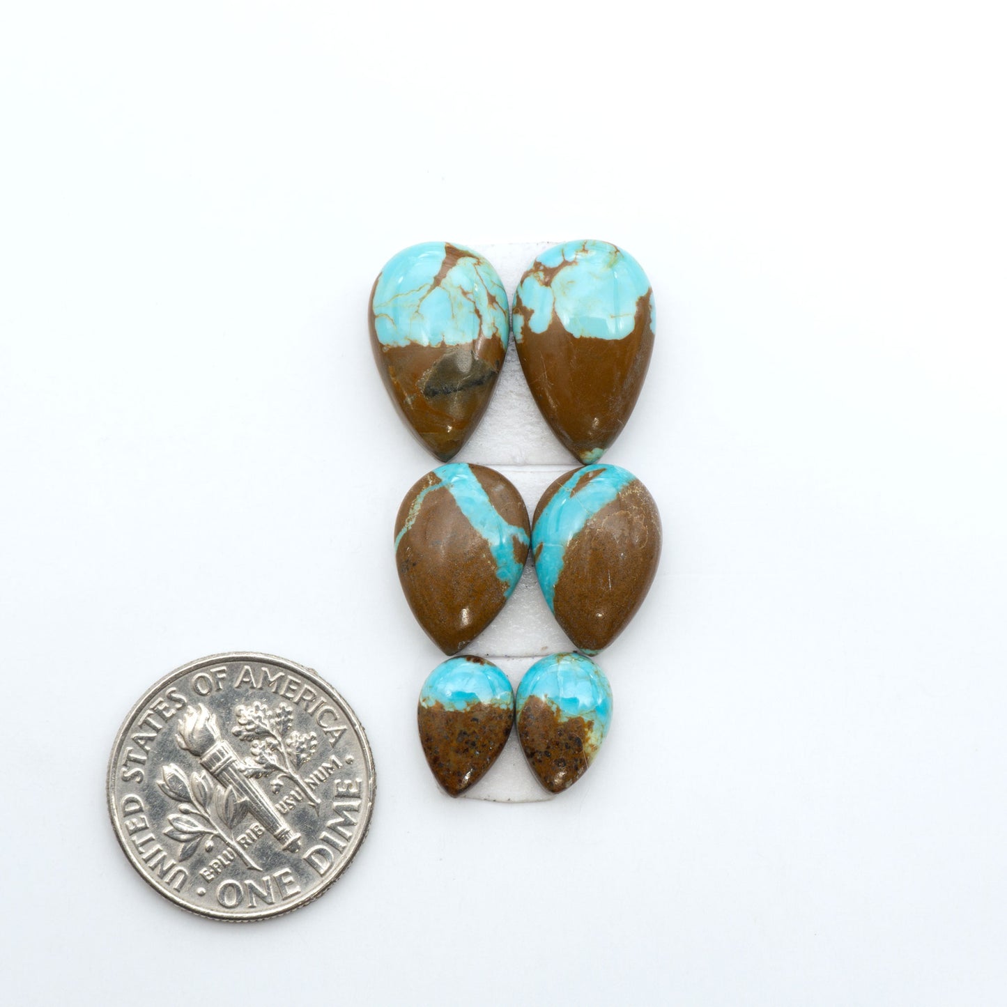 Number 8 Turquoise cabochons, blue and green color with brown matrix, polished stones on a white background, with a US dime for scale