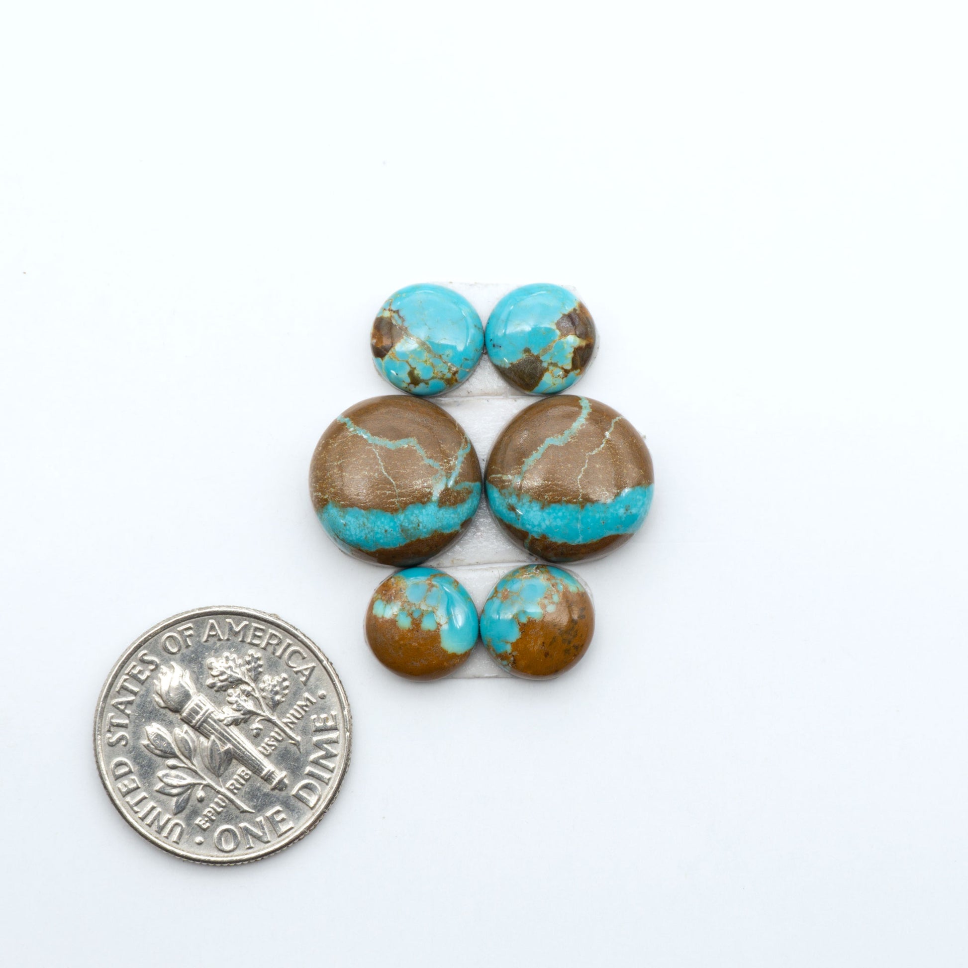Number 8 Turquoise cabochons, blue and green color with brown matrix, polished stones on a white background, with a US dime for scale