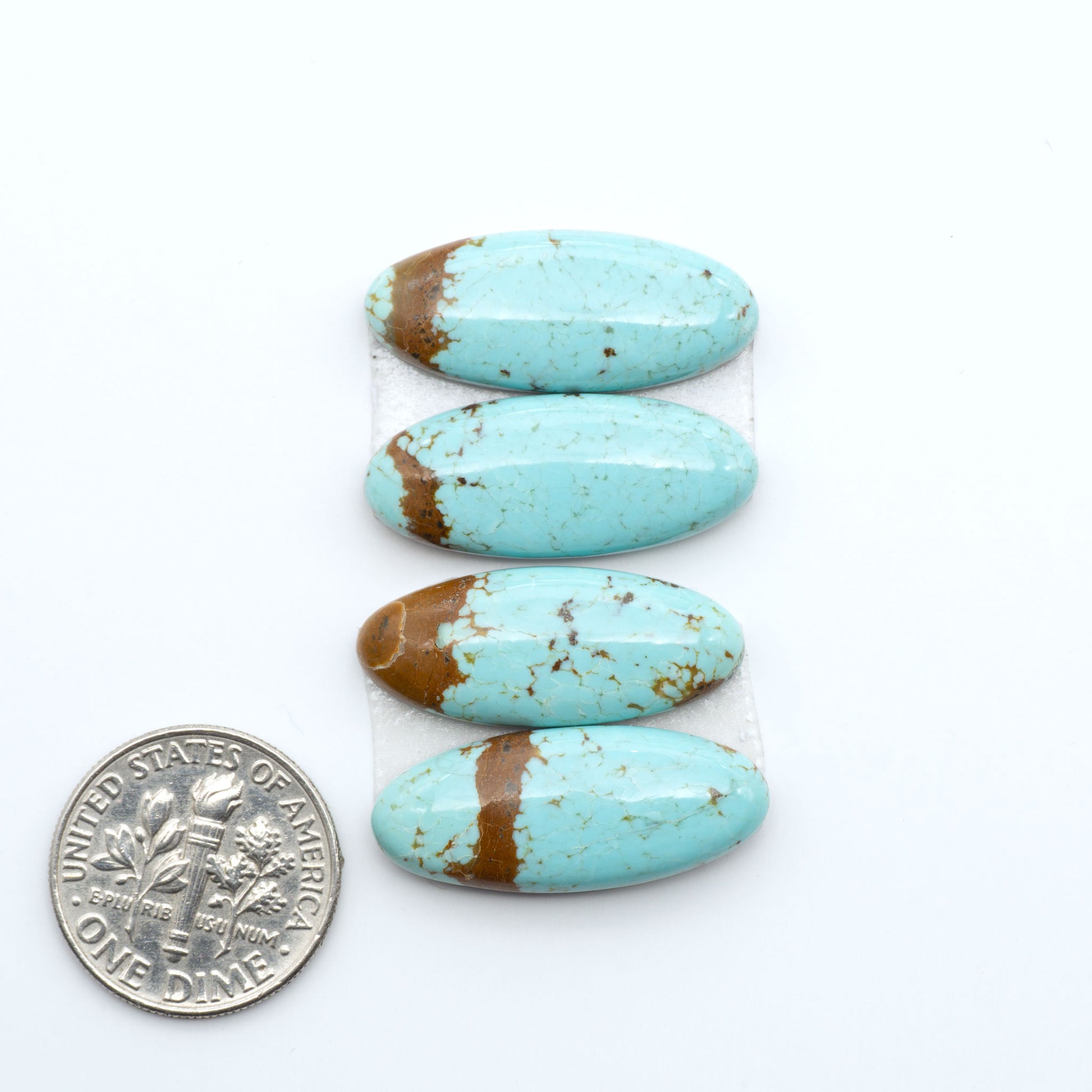Number 8 Turquoise cabochons, blue and green color with brown matrix, polished stones on a white background, with a US dime for scale