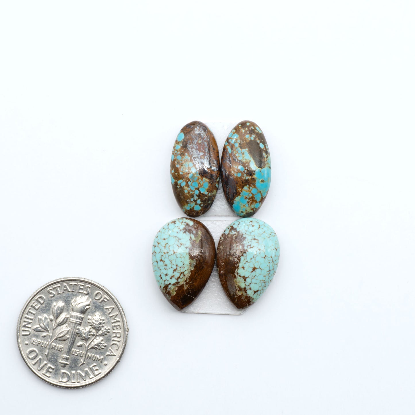Number 8 Turquoise cabochons, blue and green color with brown matrix, polished stones on a white background, with a US dime for scale