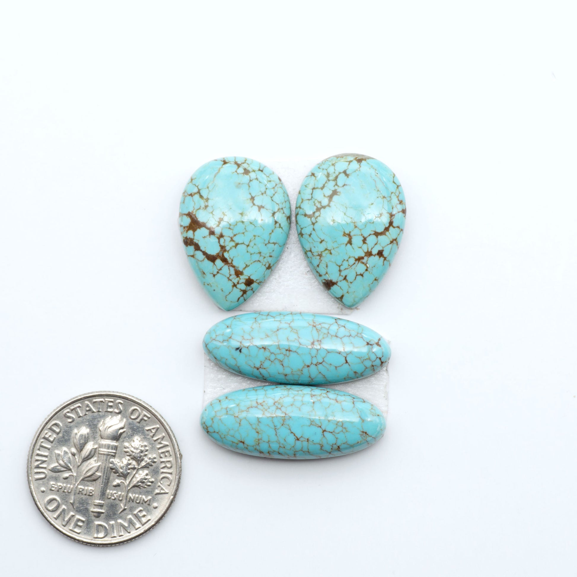 Number 8 Turquoise cabochons, blue and green color with brown matrix, polished stones on a white background, with a US dime for scale