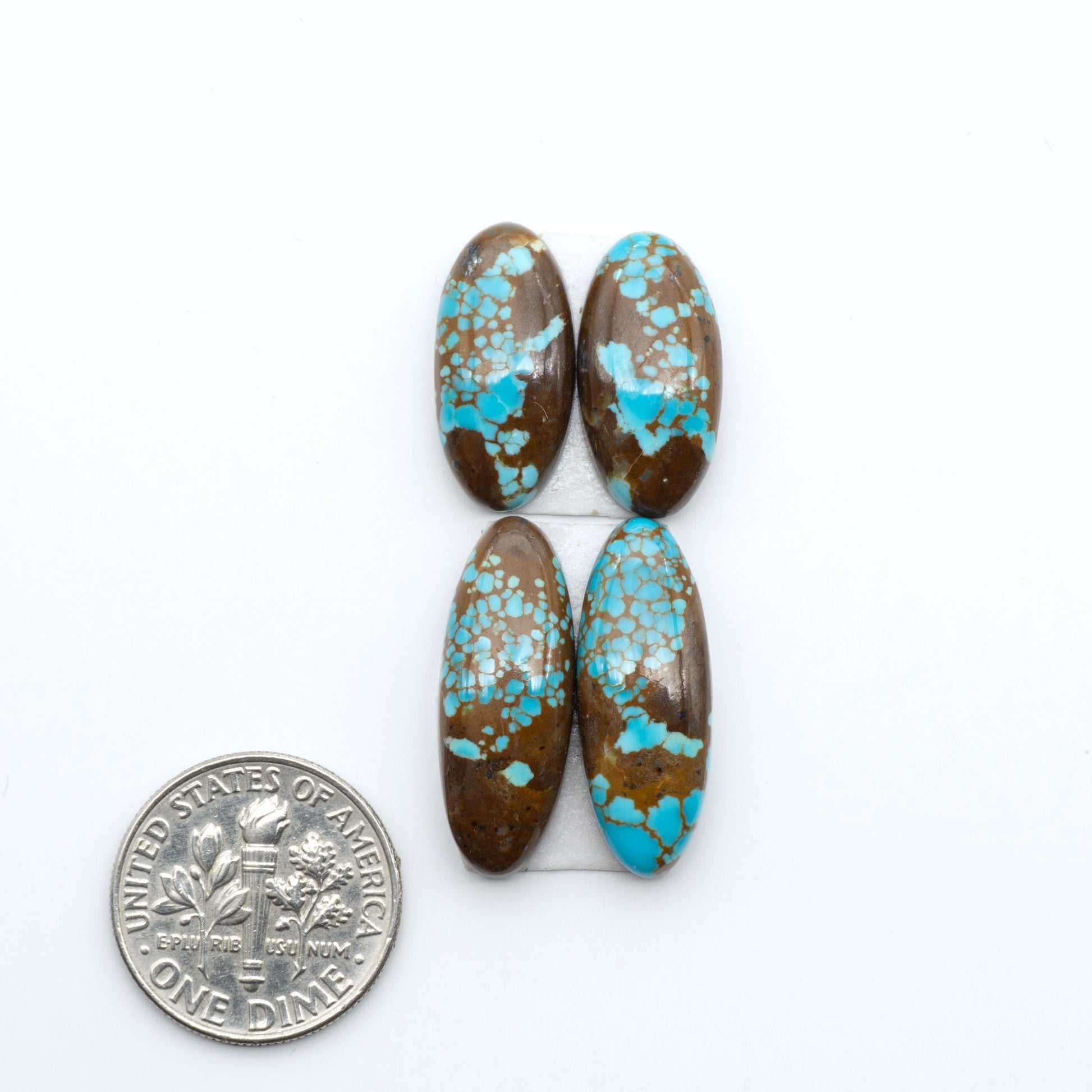 Number 8 Turquoise cabochons, blue and green color with brown matrix, polished stones on a white background, with a US dime for scale