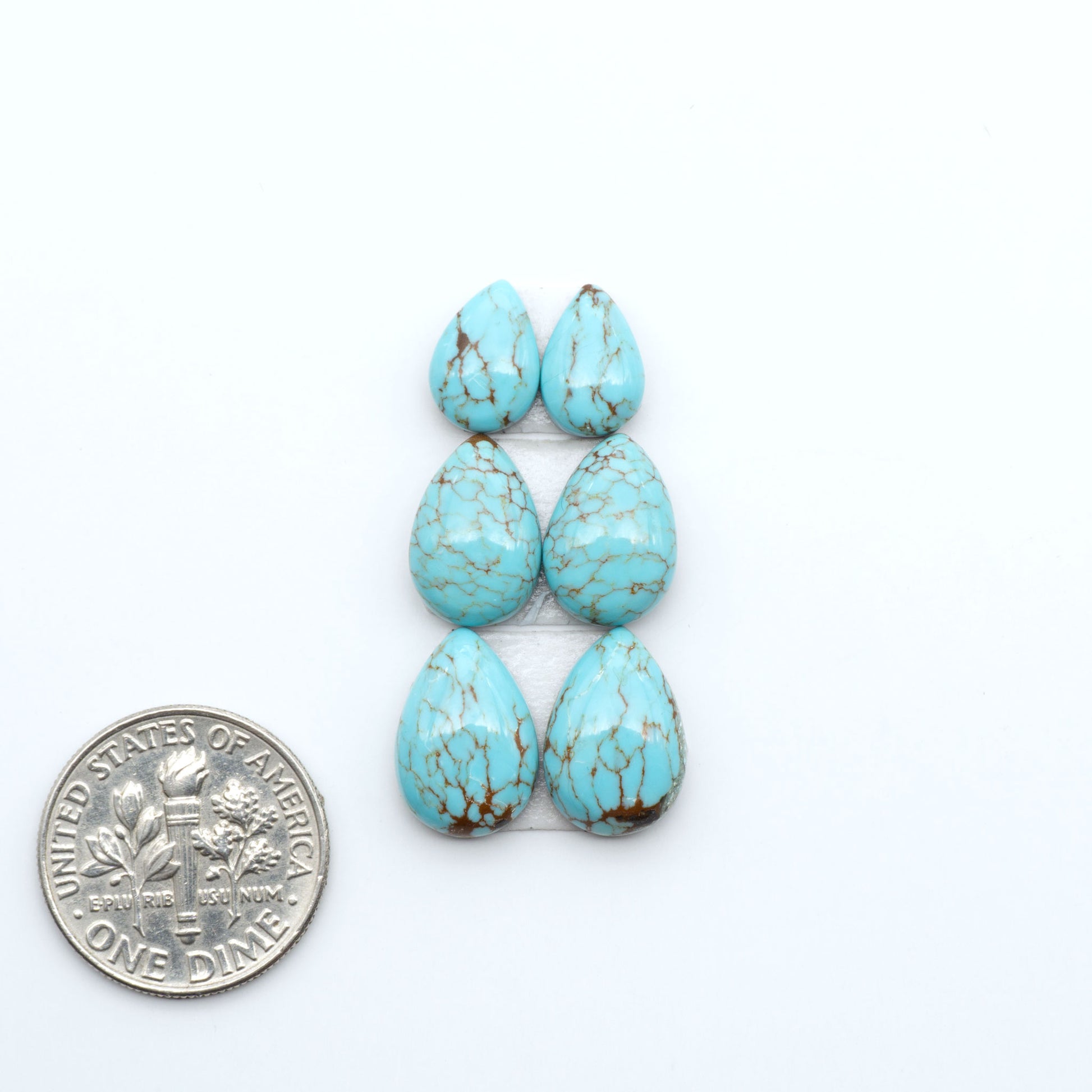 Number 8 Turquoise cabochons, blue and green color with brown matrix, polished stones on a white background, with a US dime for scale