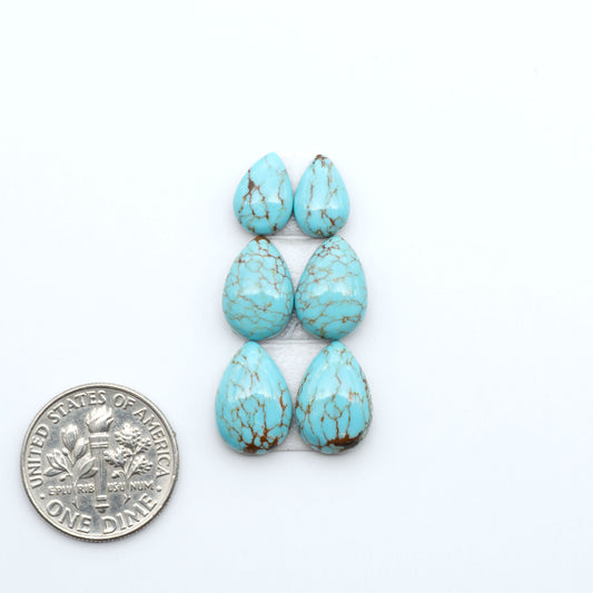 Number 8 Turquoise cabochons, blue and green color with brown matrix, polished stones on a white background, with a US dime for scale