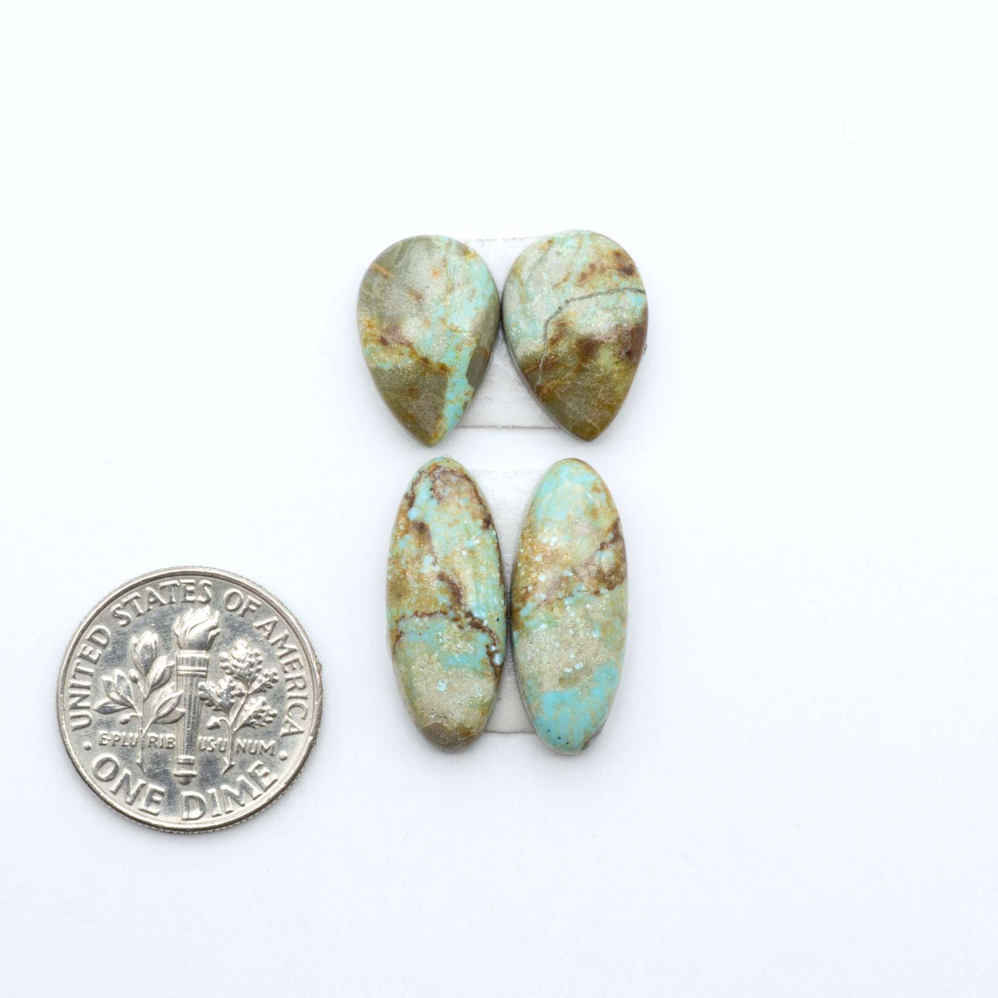 Number 8 Turquoise cabochons, blue and green color with brown matrix, polished stones on a white background, with a US dime for scale