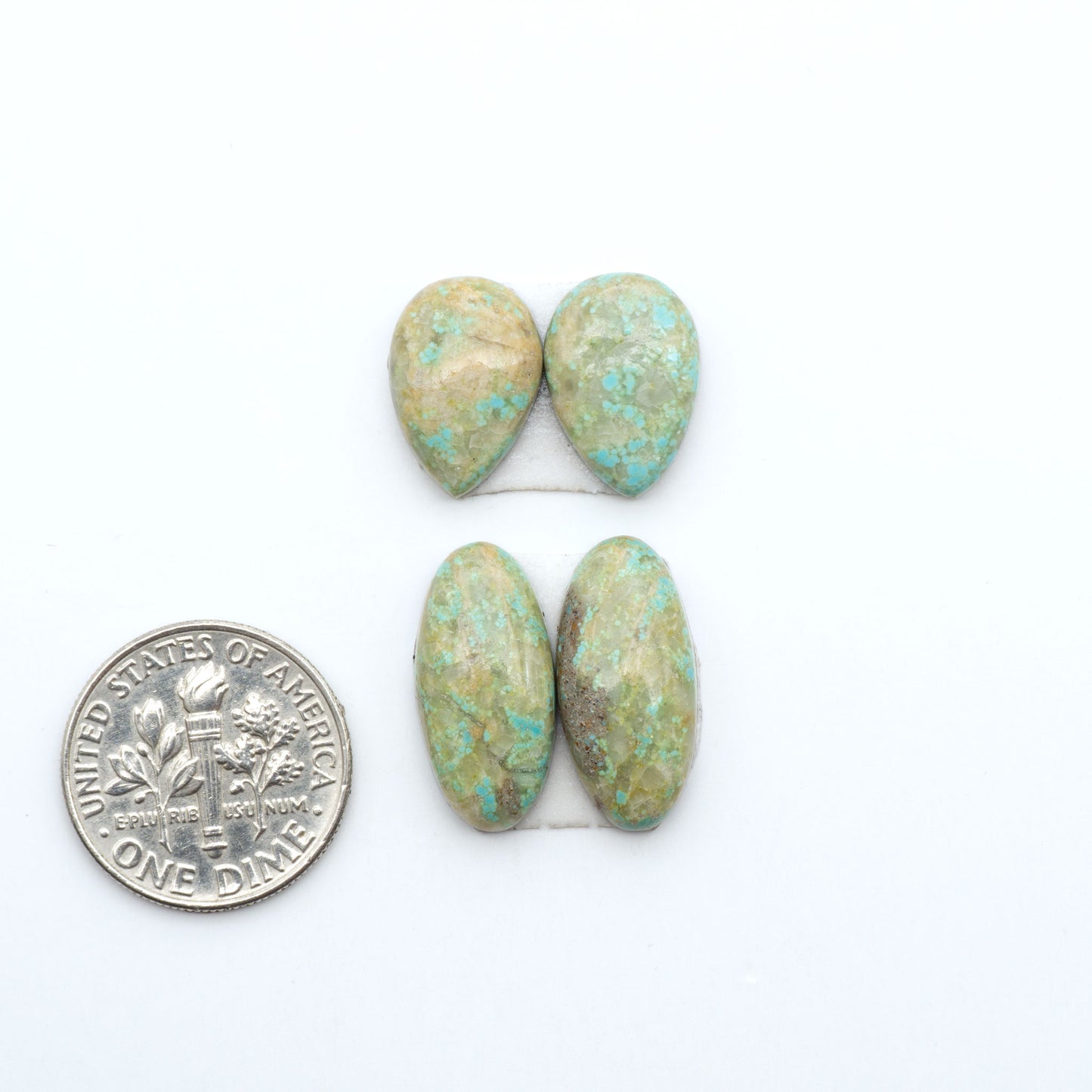 Number 8 Turquoise cabochons, blue and green color with brown matrix, polished stones on a white background, with a US dime for scale