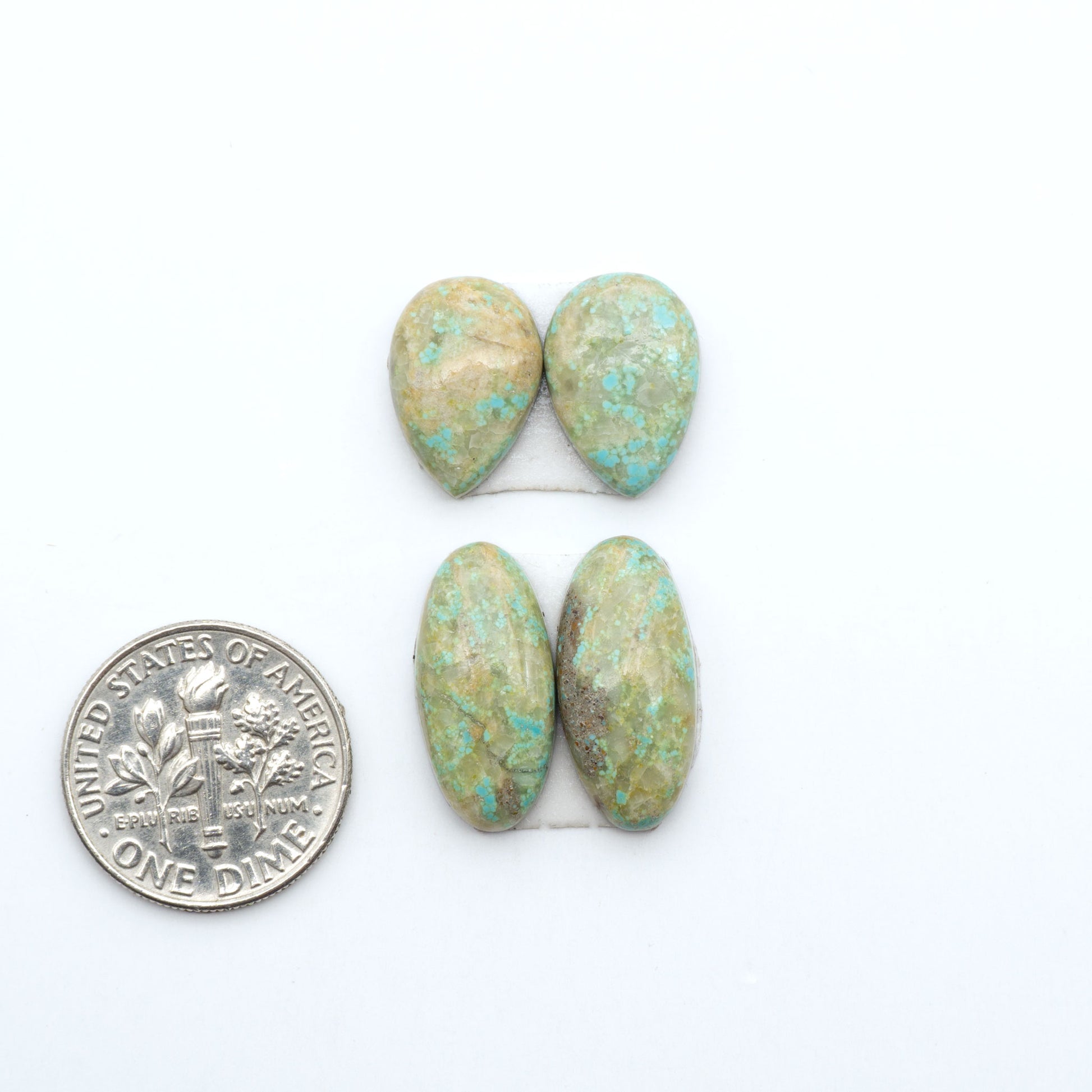 Number 8 Turquoise cabochons, blue and green color with brown matrix, polished stones on a white background, with a US dime for scale