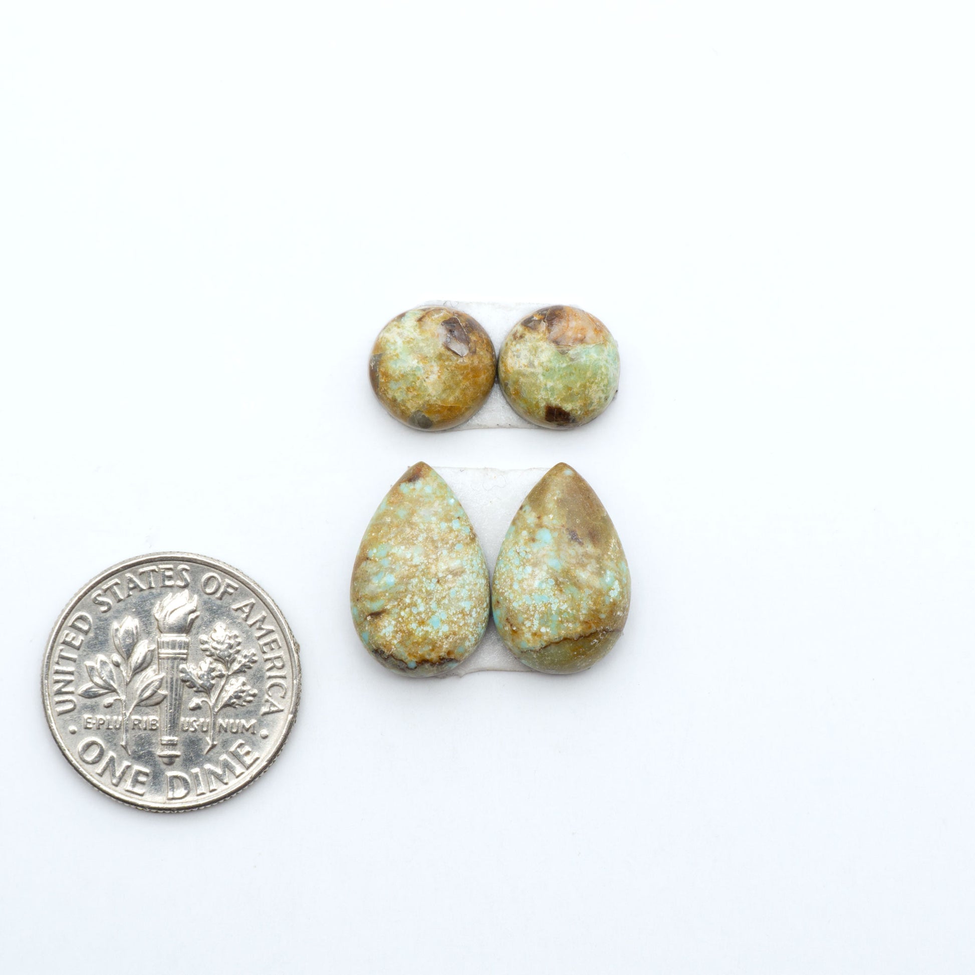 Number 8 Turquoise cabochons, blue and green color with brown matrix, polished stones on a white background, with a US dime for scale