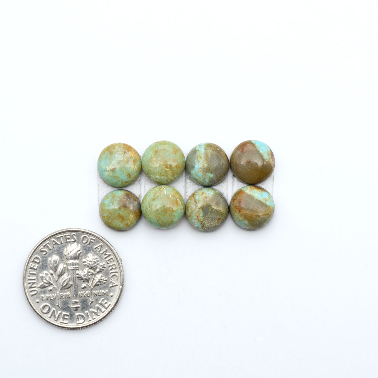 Number 8 Turquoise cabochons, blue and green color with brown matrix, polished stones on a white background, with a US dime for scale