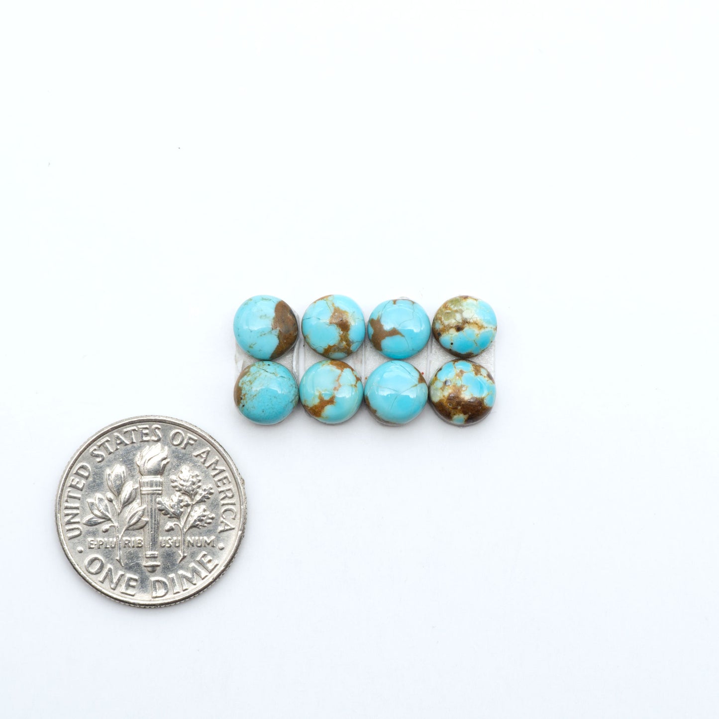 Number 8 Turquoise cabochons, blue and green color with brown matrix, polished stones on a white background, with a US dime for scale