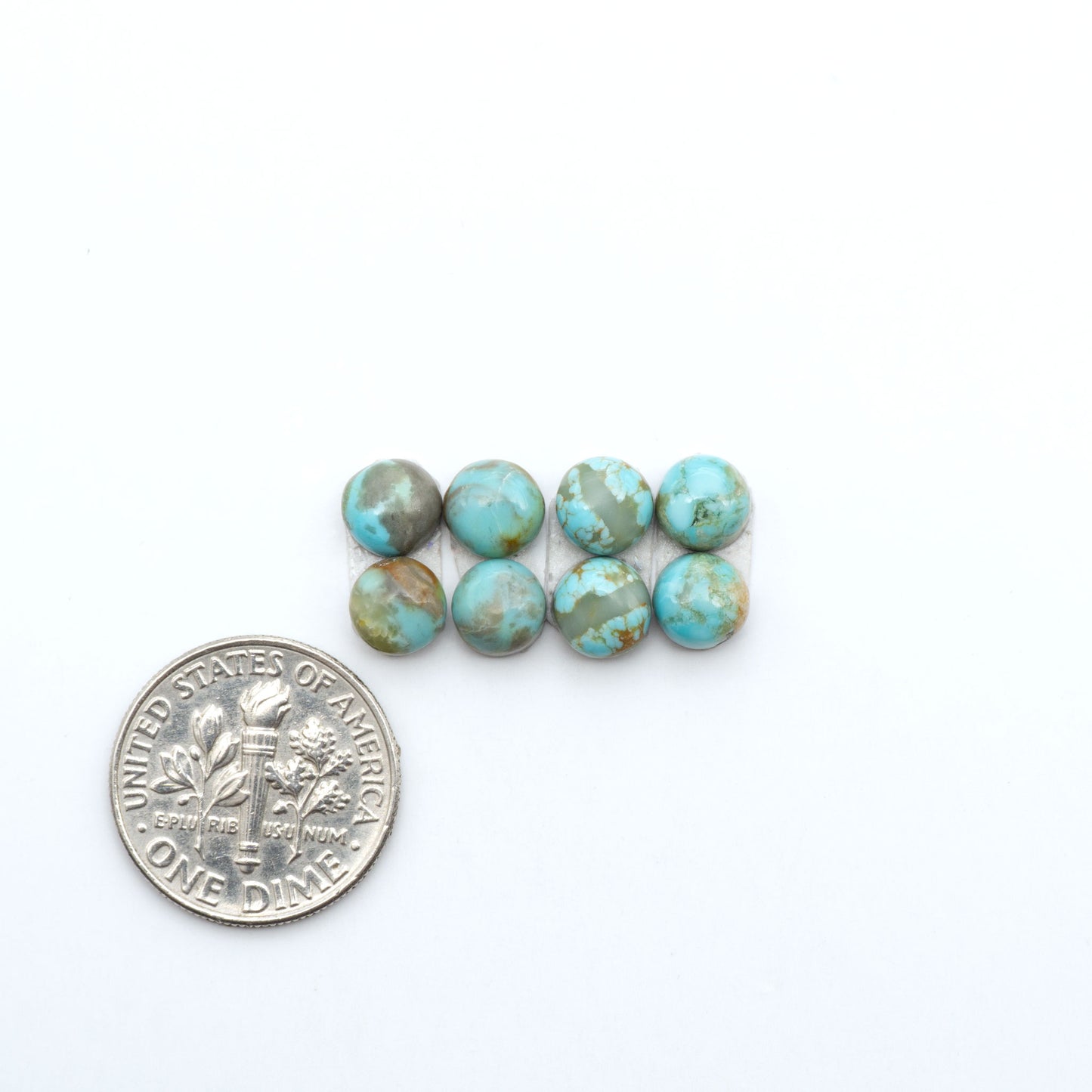 Number 8 Turquoise cabochons, blue and green color with brown matrix, polished stones on a white background, with a US dime for scale