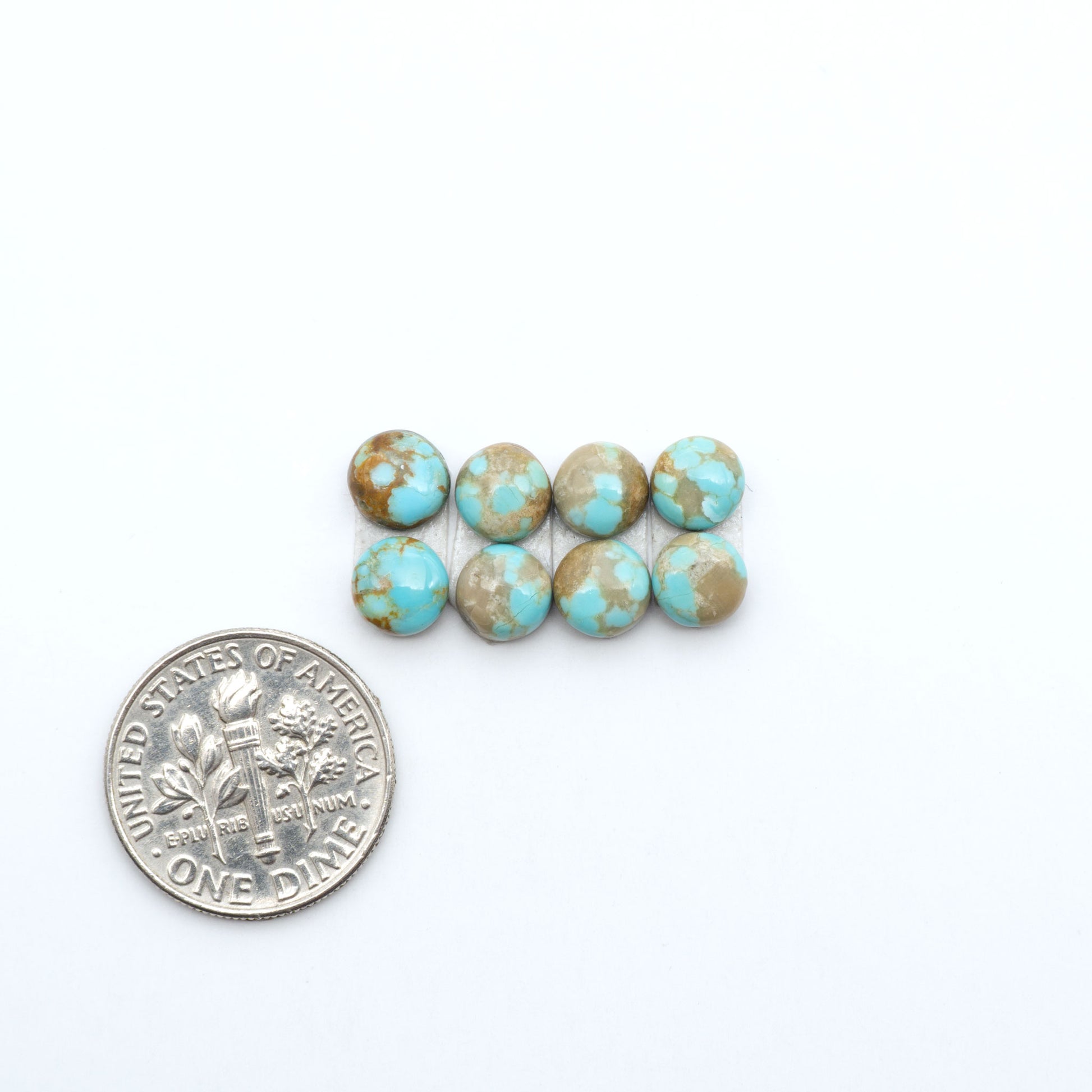 Number 8 Turquoise cabochons, blue and green color with brown matrix, polished stones on a white background, with a US dime for scale