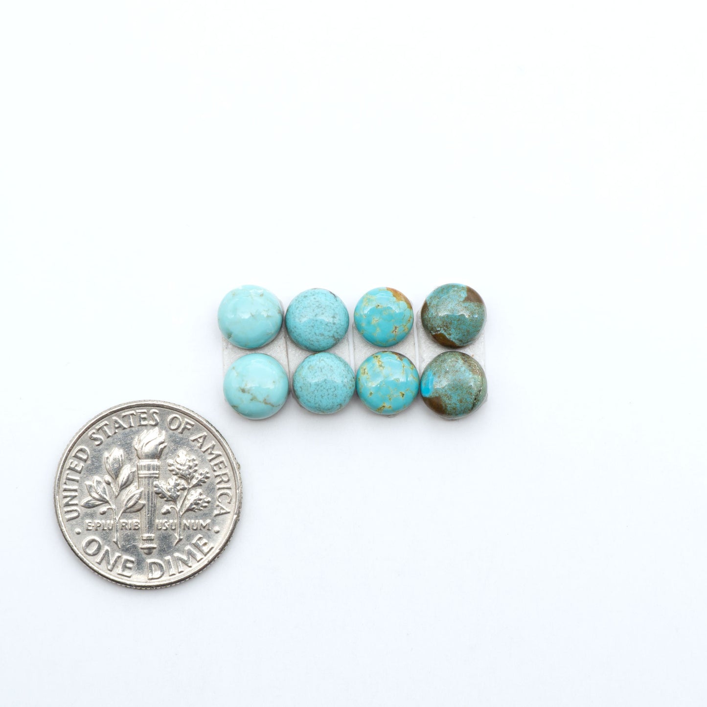 Number 8 Turquoise cabochons, blue and green color with brown matrix, polished stones on a white background, with a US dime for scale