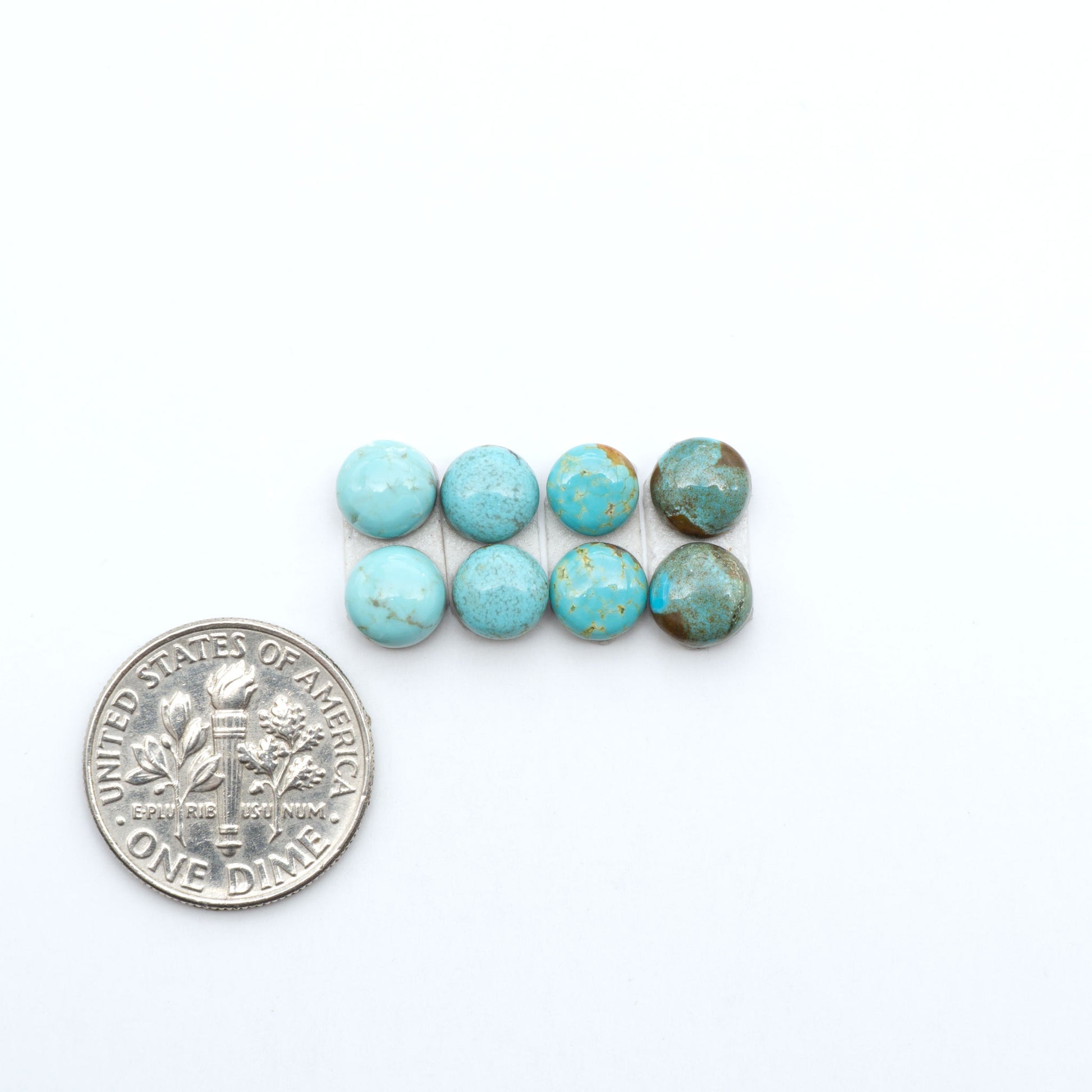 Number 8 Turquoise cabochons, blue and green color with brown matrix, polished stones on a white background, with a US dime for scale
