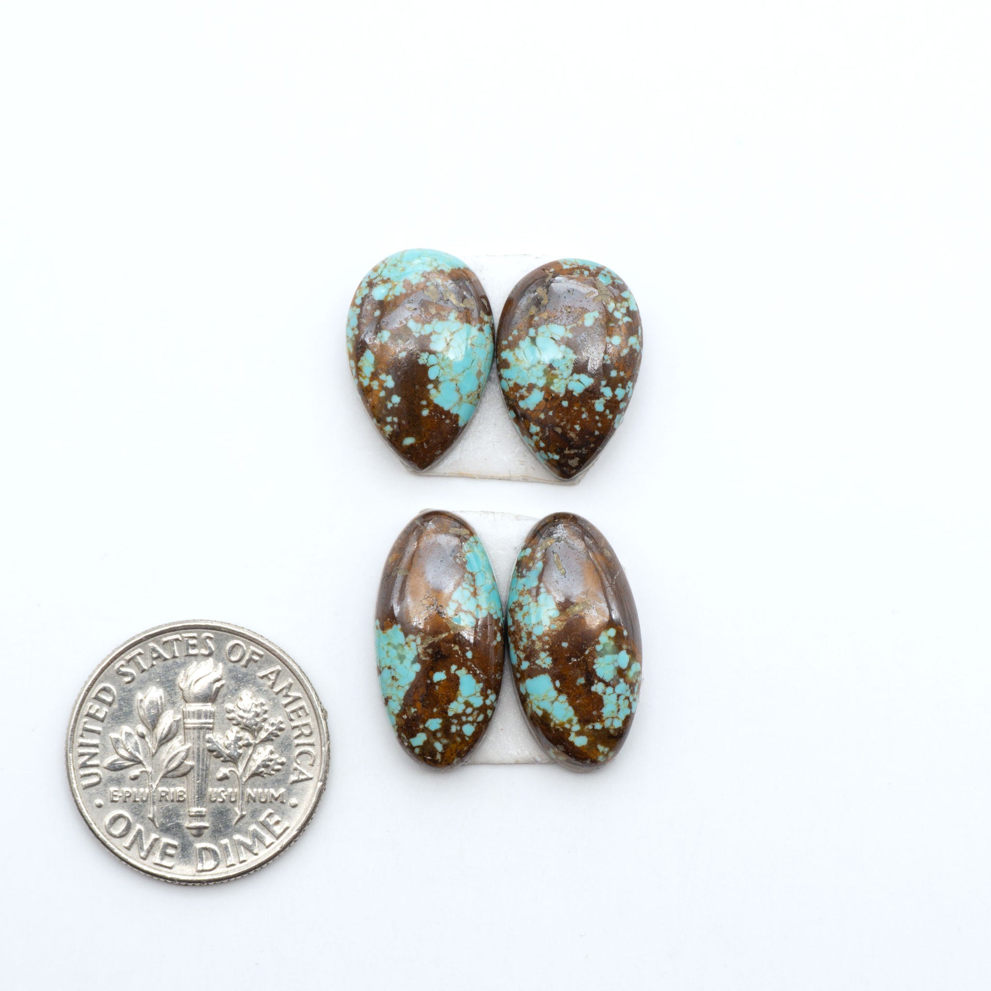Number 8 Turquoise cabochons, blue and green color with brown matrix, polished stones on a white background, with a US dime for scale