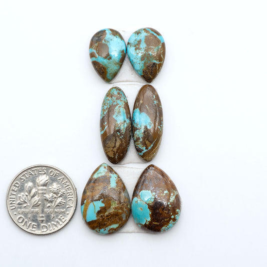 Number 8 Turquoise cabochons, blue and green color with brown matrix, polished stones on a white background, with a US dime for scale