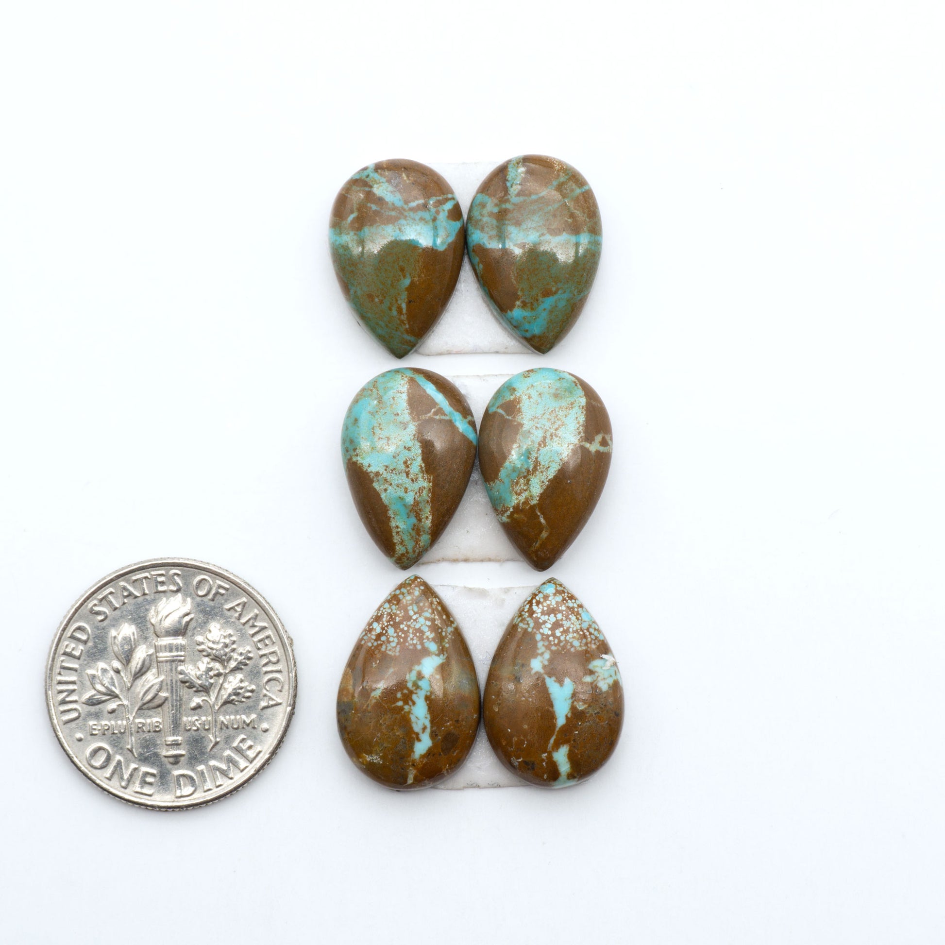 Number 8 Turquoise cabochons, blue and green color with brown matrix, polished stones on a white background, with a US dime for scale