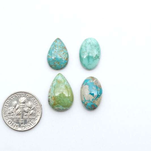 Fox Turquoise cabochons, polished gemstones with natural matrix on a white background, with a US dime for scale