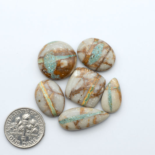 Royston Turquoise cabochons, blue-green color with natural matrix, polished stones on a white background, with a US dime for scale