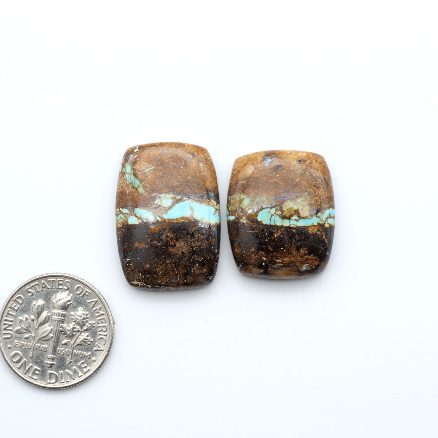 Royston Turquoise cabochons, blue-green color with natural matrix, polished stones on a white background, with a US dime for scale