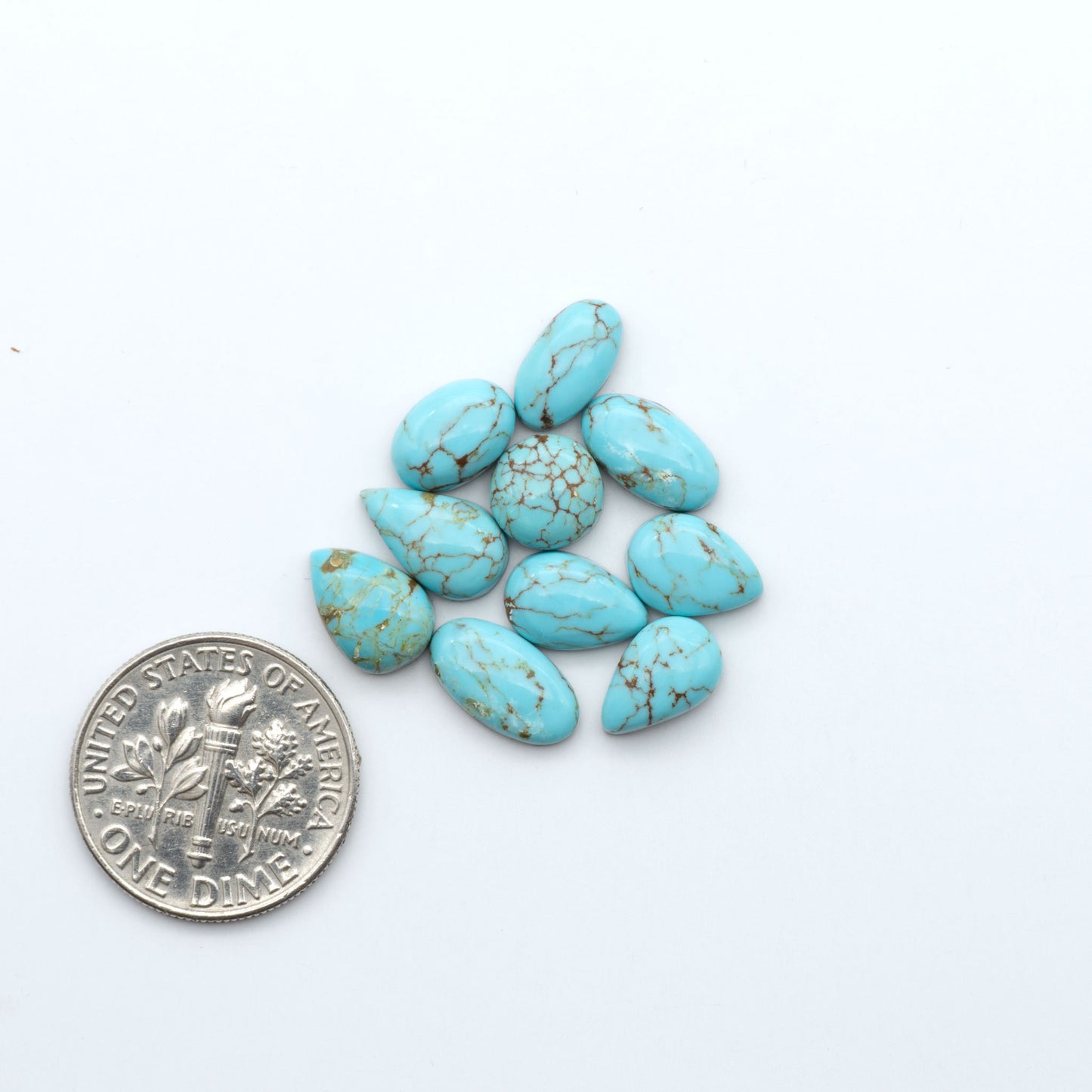Number 8 Turquoise cabochons, blue and green color with brown matrix, polished stones on a white background, with a US dime for scale