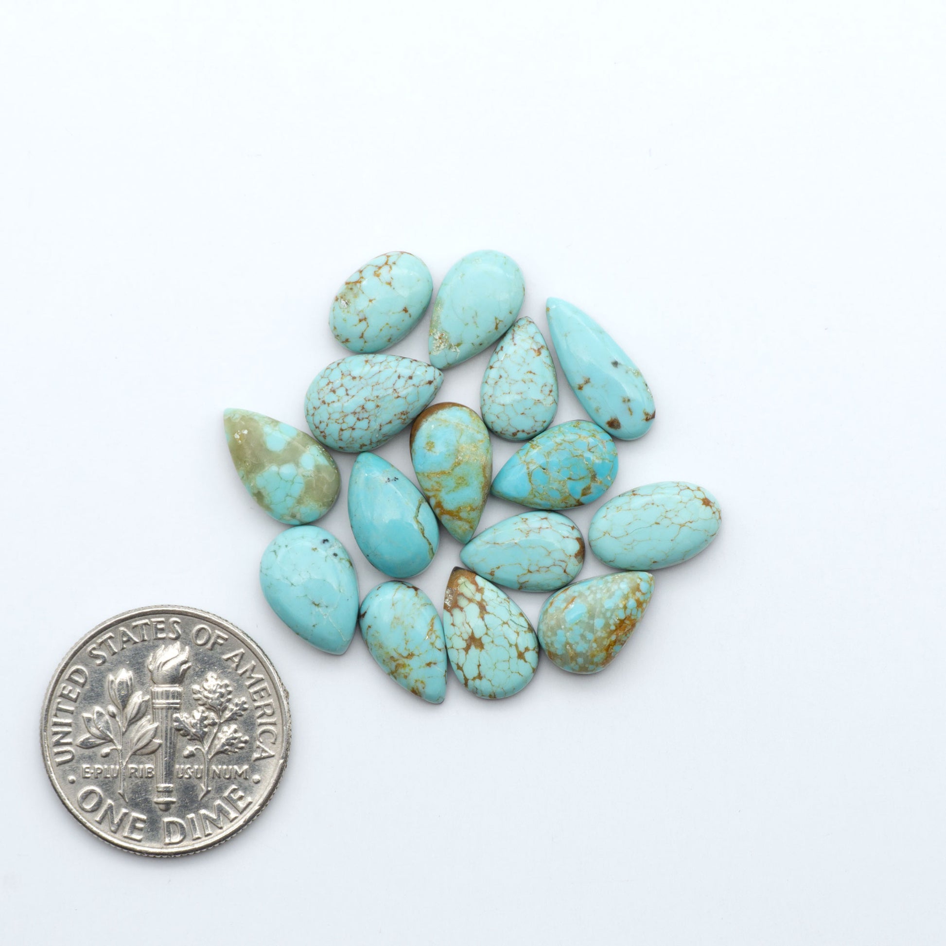 Number 8 Turquoise cabochons, blue and green color with brown matrix, polished stones on a white background, with a US dime for scale