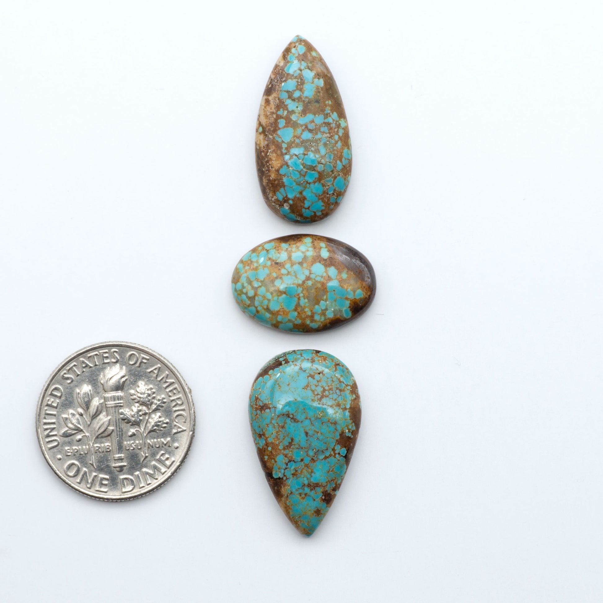 Number 8 Turquoise cabochons, blue and green color with brown matrix, polished stones on a white background, with a US dime for scale