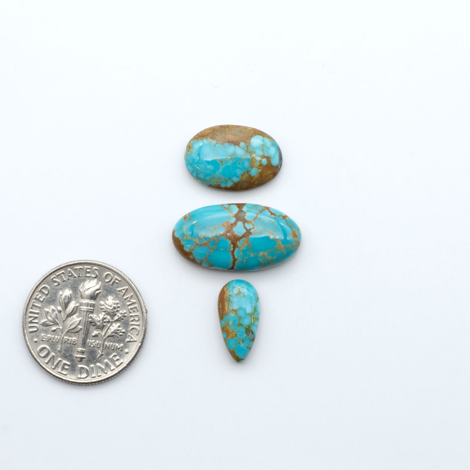 Number 8 Turquoise cabochons, blue and green color with brown matrix, polished stones on a white background, with a US dime for scale
