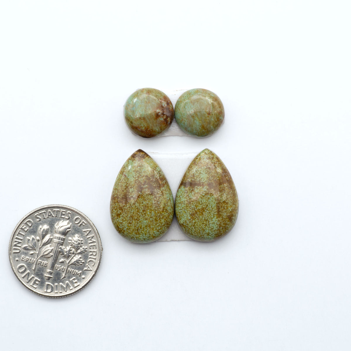 Number 8 Turquoise cabochons, blue and green color with brown matrix, polished stones on a white background, with a US dime for scale