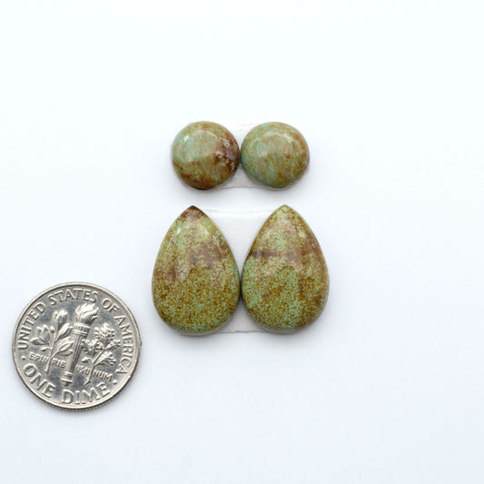 Number 8 Turquoise cabochons, blue and green color with brown matrix, polished stones on a white background, with a US dime for scale