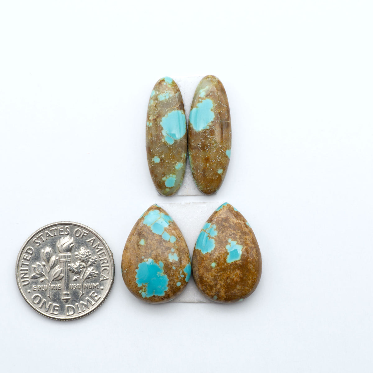 Number 8 Turquoise cabochons, blue and green color with brown matrix, polished stones on a white background, with a US dime for scale