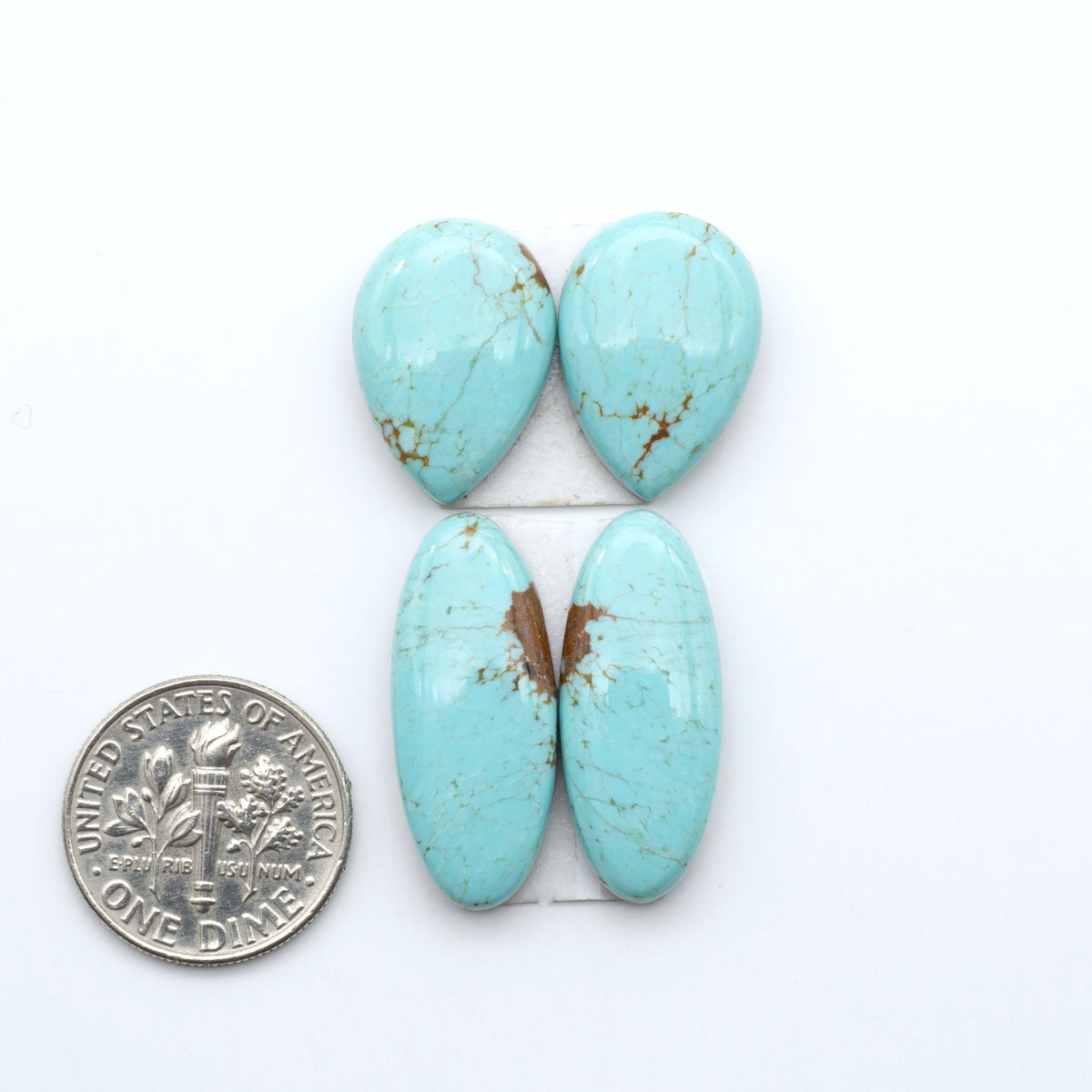 Number 8 Turquoise cabochons, blue and green color with brown matrix, polished stones on a white background, with a US dime for scale