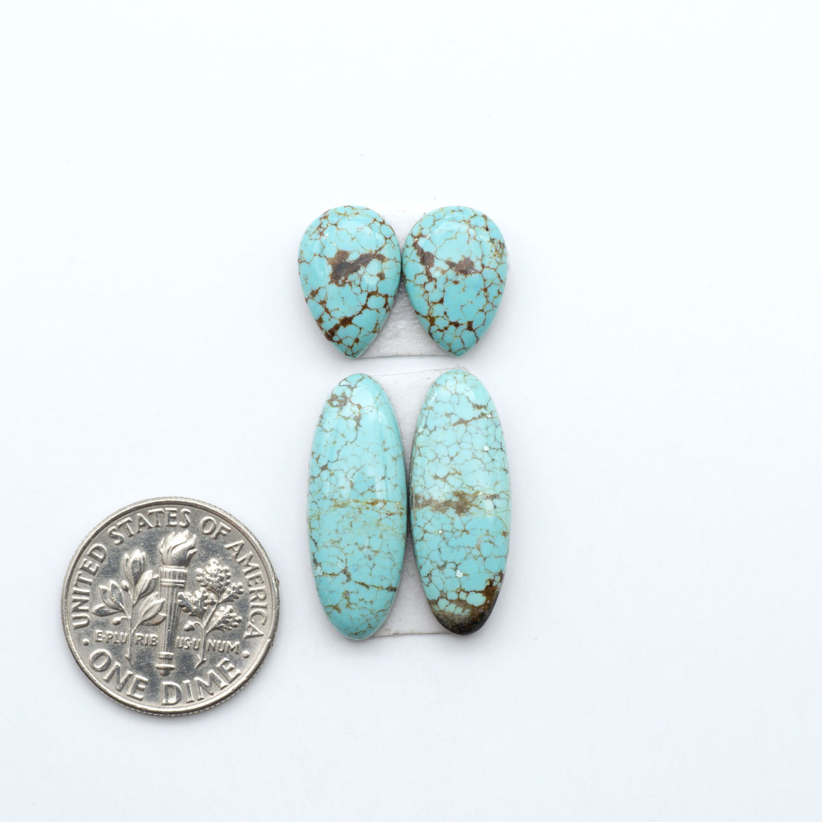 Number 8 Turquoise cabochons, blue and green color with brown matrix, polished stones on a white background, with a US dime for scale