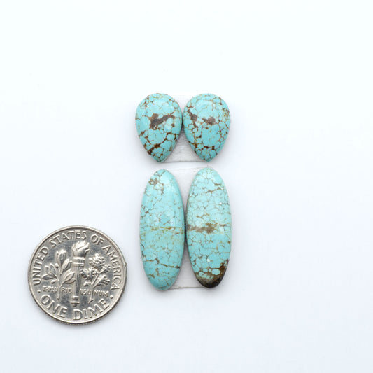 Number 8 Turquoise cabochons, blue and green color with brown matrix, polished stones on a white background, with a US dime for scale
