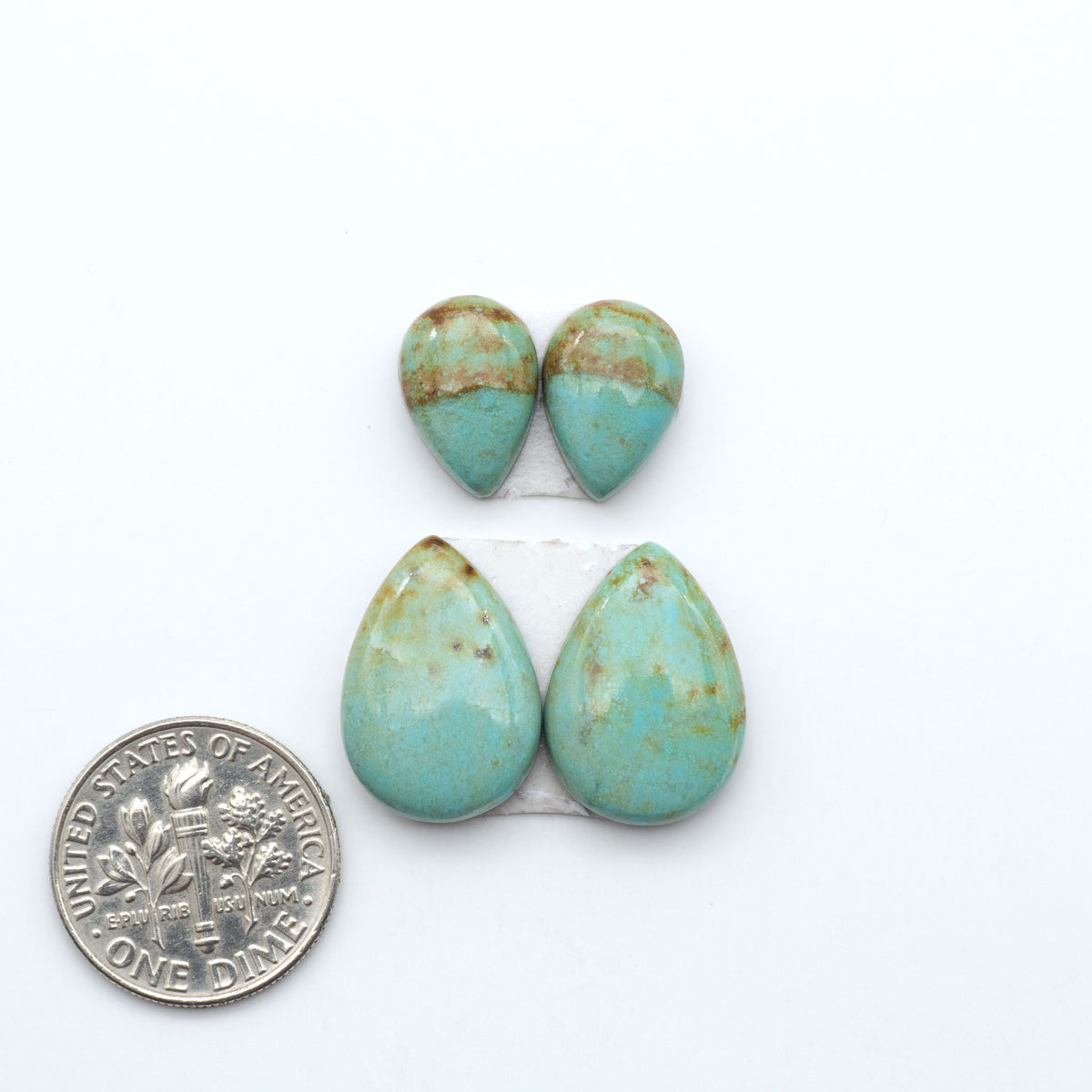 Number 8 Turquoise cabochons, blue and green color with brown matrix, polished stones on a white background, with a US dime for scale