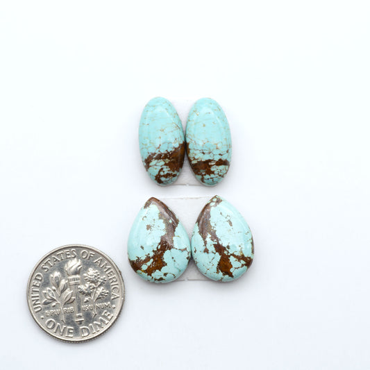 Number 8 Turquoise cabochons, blue and green color with brown matrix, polished stones on a white background, with a US dime for scale