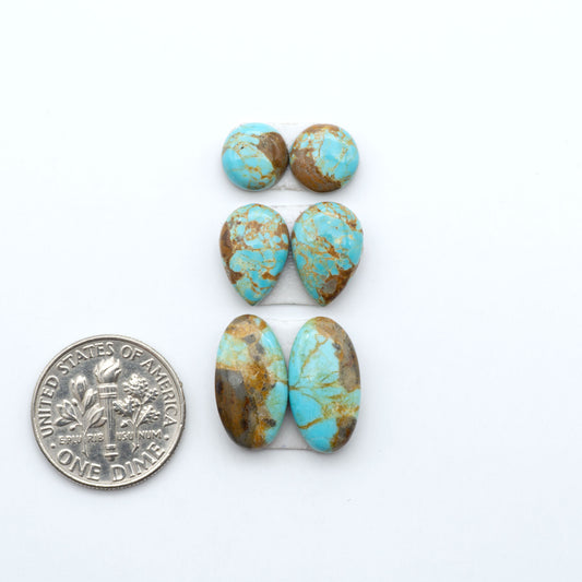 Number 8 Turquoise cabochons, blue and green color with brown matrix, polished stones on a white background, with a US dime for scale
