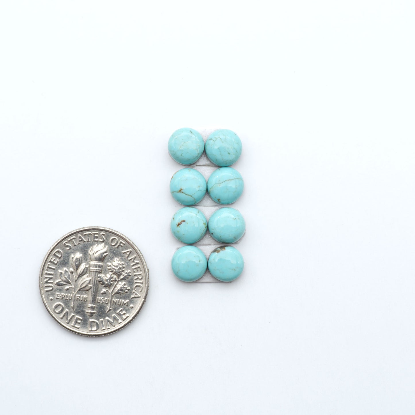 Number 8 Turquoise cabochons, blue and green color with brown matrix, polished stones on a white background, with a US dime for scale