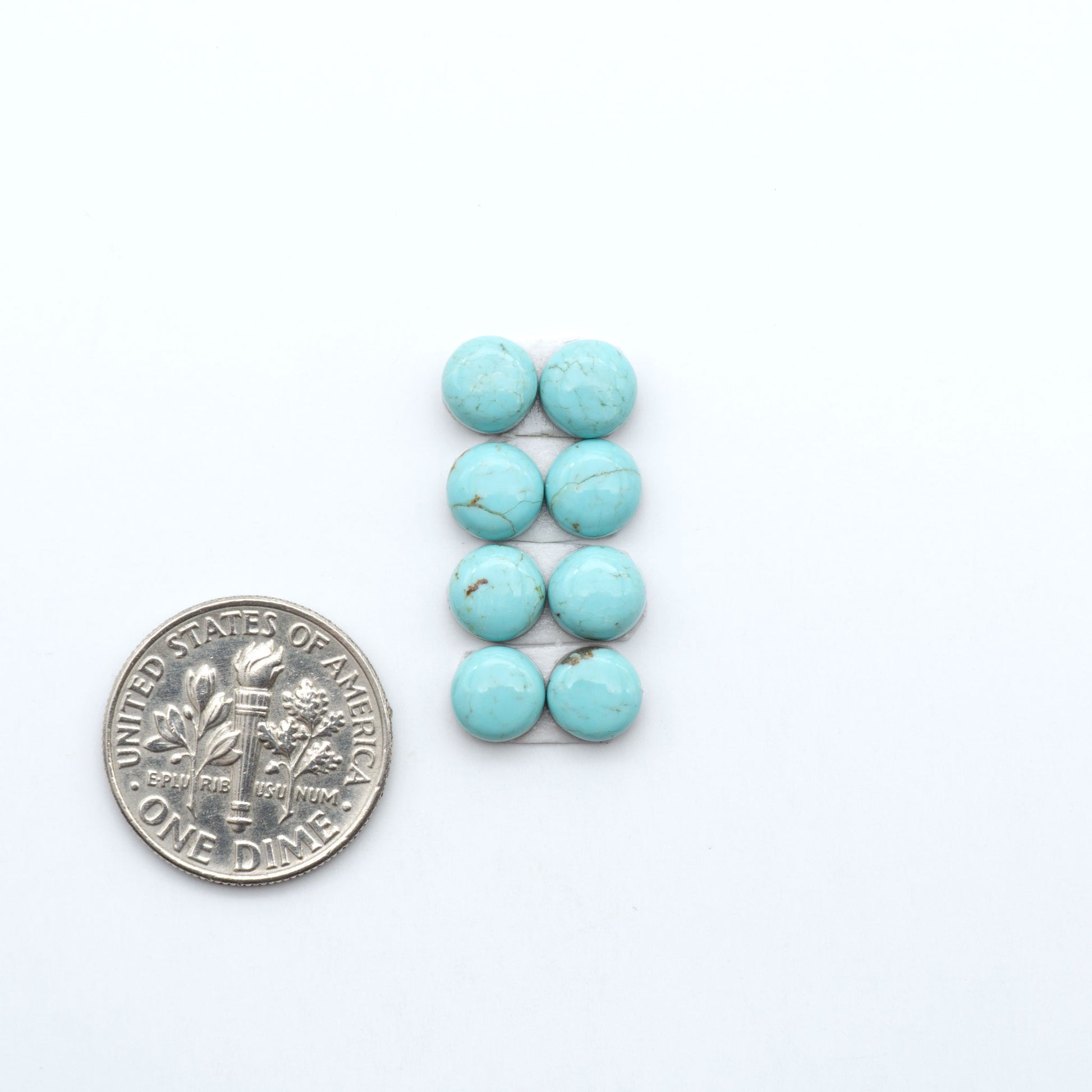 Number 8 Turquoise cabochons, blue and green color with brown matrix, polished stones on a white background, with a US dime for scale