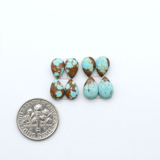 Number 8 Turquoise cabochons, blue and green color with brown matrix, polished stones on a white background, with a US dime for scale