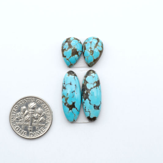 Number 8 Turquoise cabochons, blue and green color with brown matrix, polished stones on a white background, with a US dime for scale