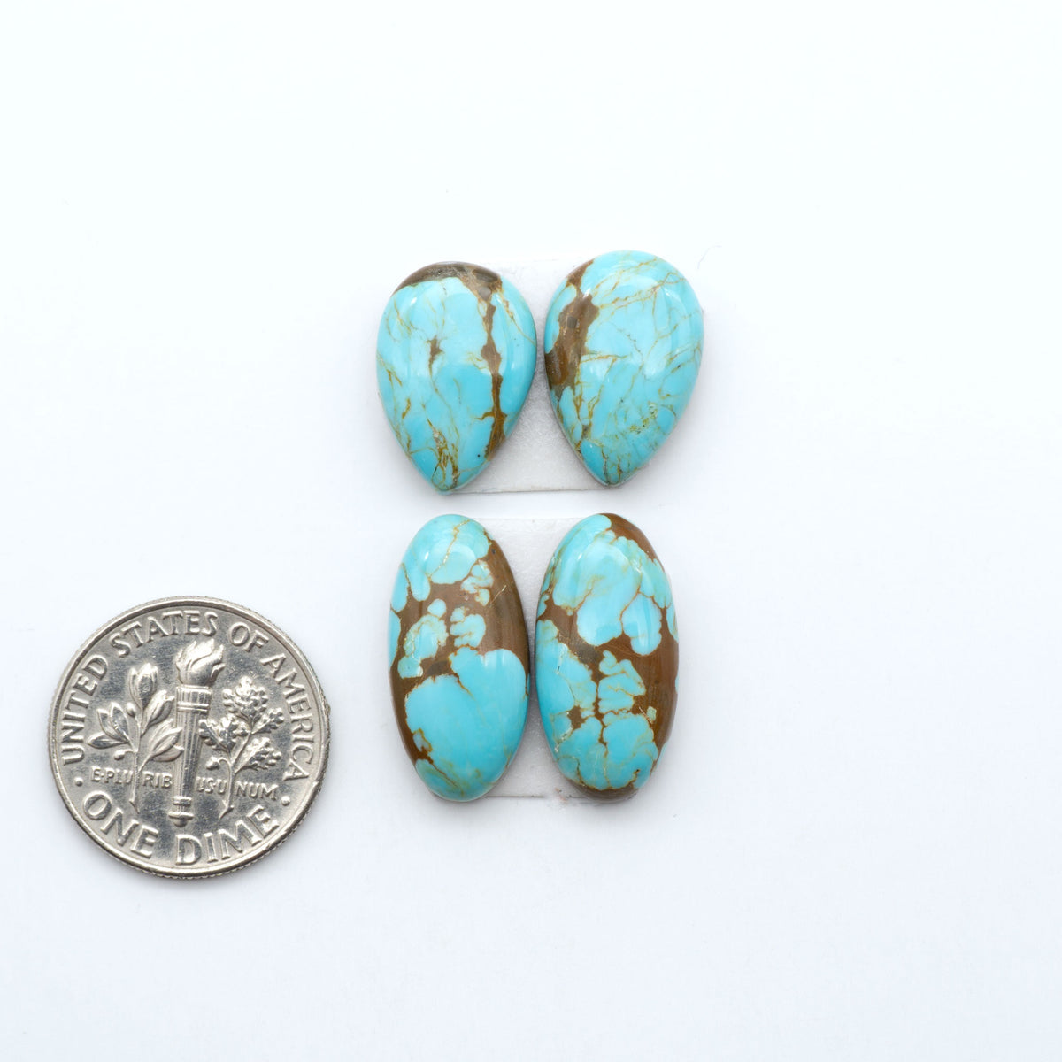 Number 8 Turquoise cabochons, blue and green color with brown matrix, polished stones on a white background, with a US dime for scale