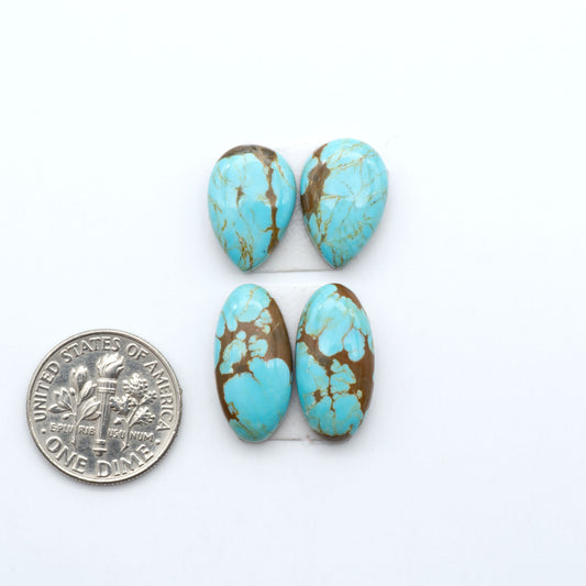 Number 8 Turquoise cabochons, blue and green color with brown matrix, polished stones on a white background, with a US dime for scale
