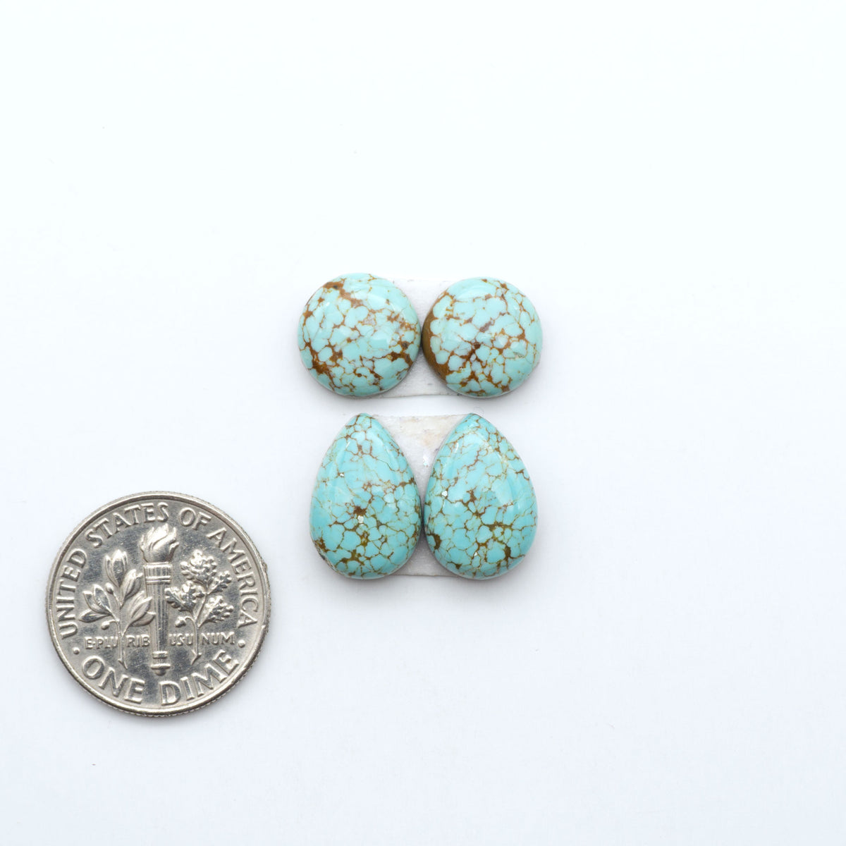 Number 8 Turquoise cabochons, blue and green color with brown matrix, polished stones on a white background, with a US dime for scale